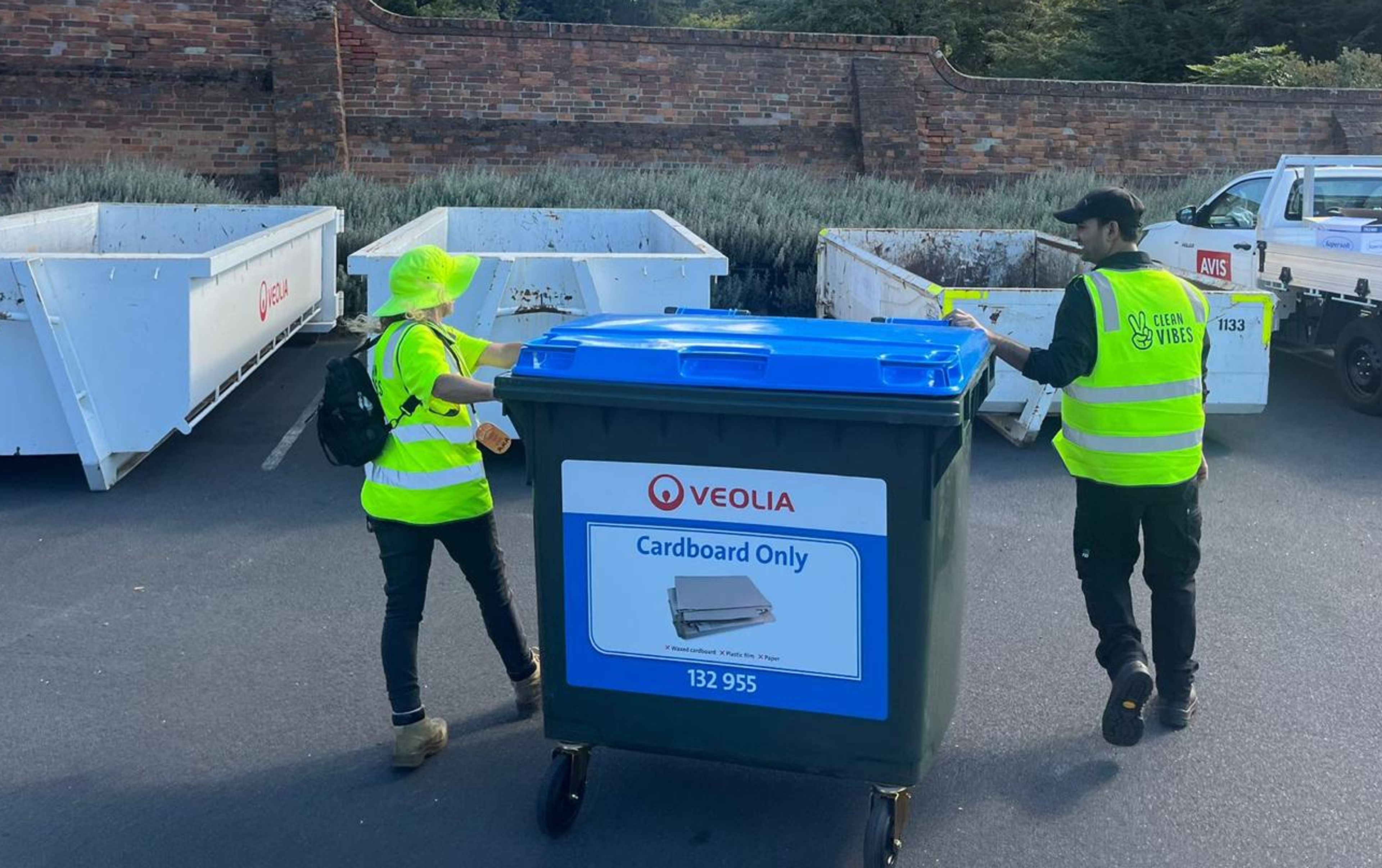 Clean Vibes employees taking out a bin to skip bins