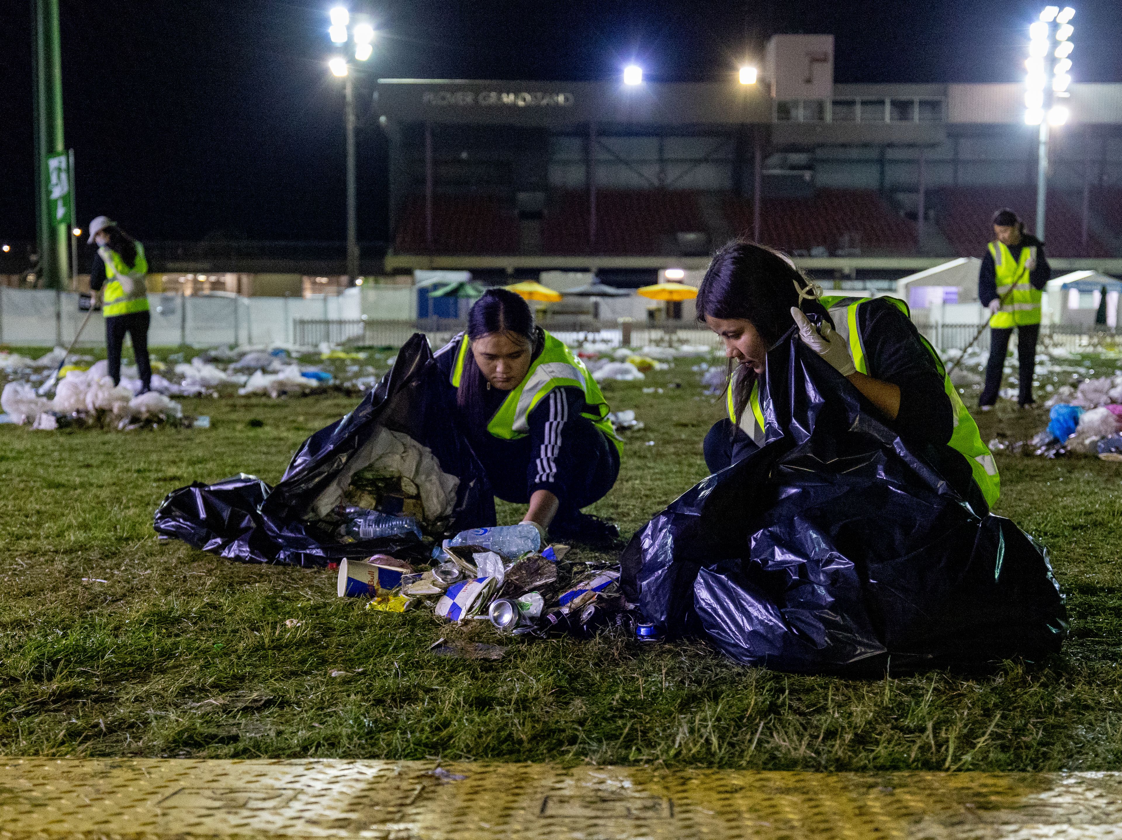 Clean Vibes staffs picking up garbages from the floor at night post event