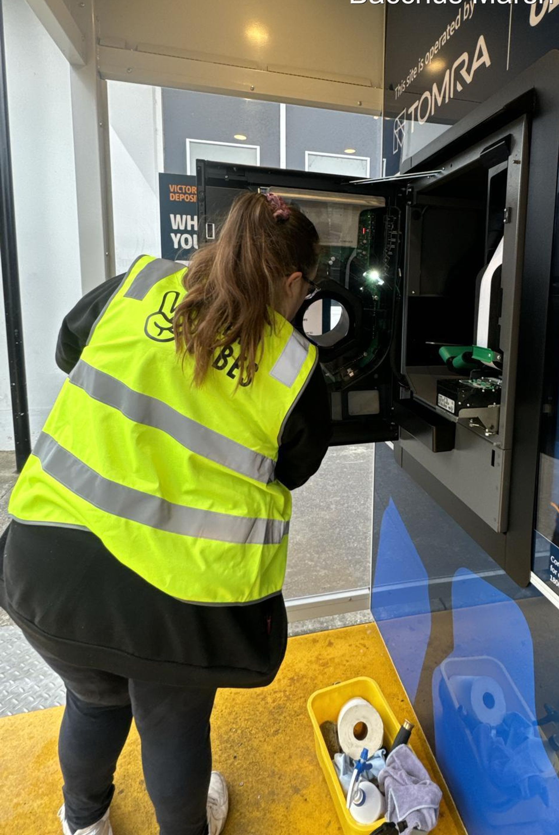 Clean Vibes staff cleaning the inside of a RVM machine