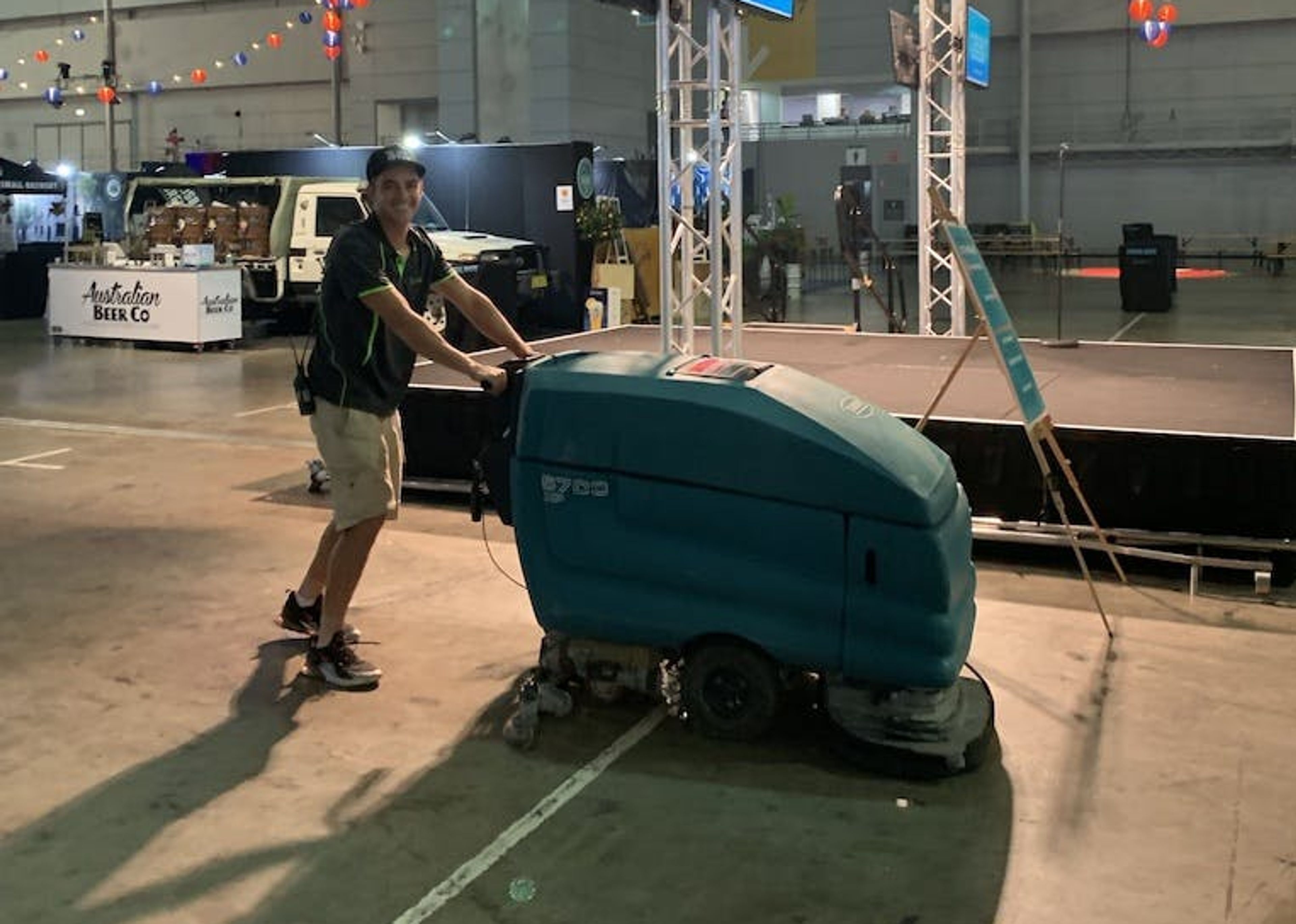 Clean Vibes staff cleaning venue floor with machine