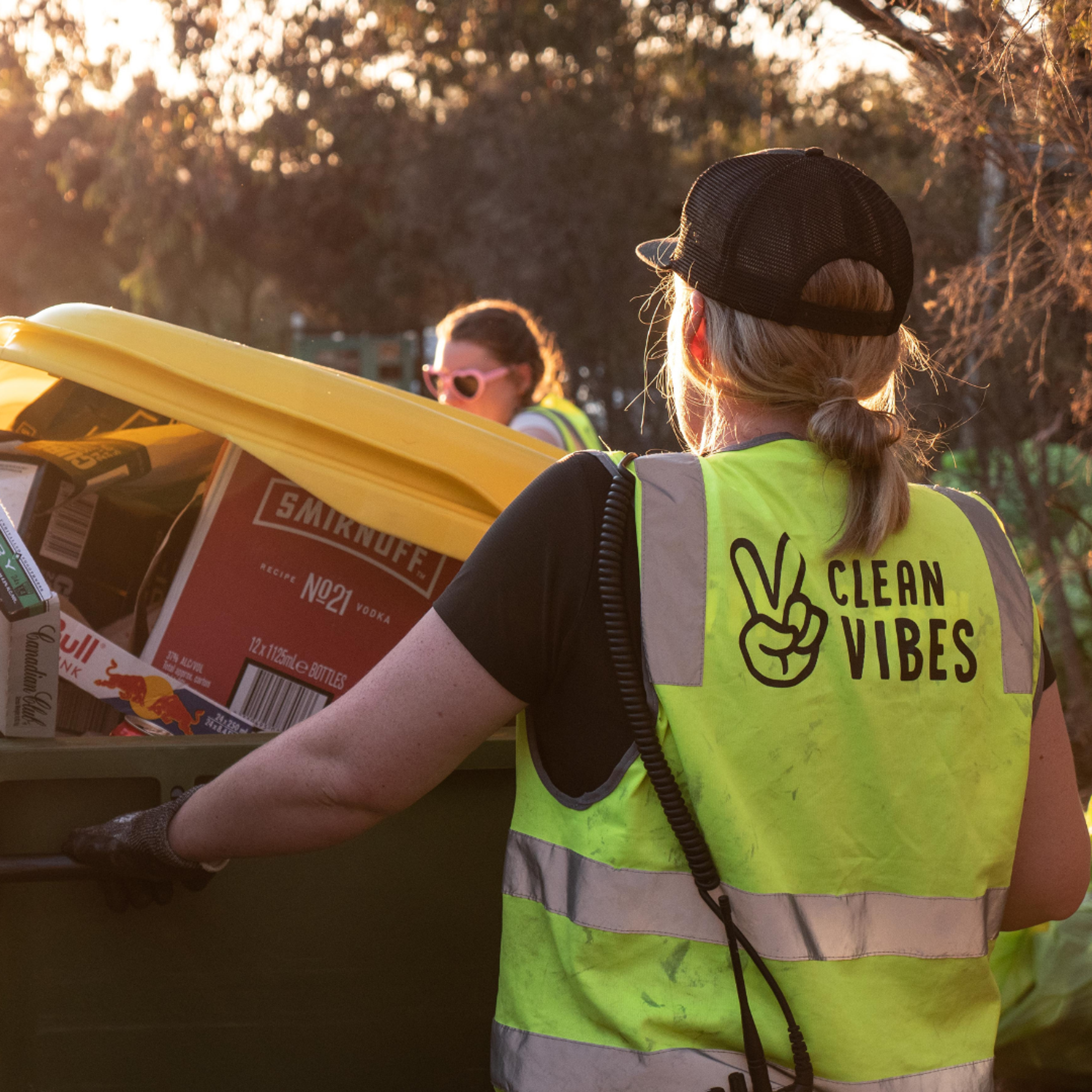 Clean Vibes employee moving a wheeling bin full of cardboards