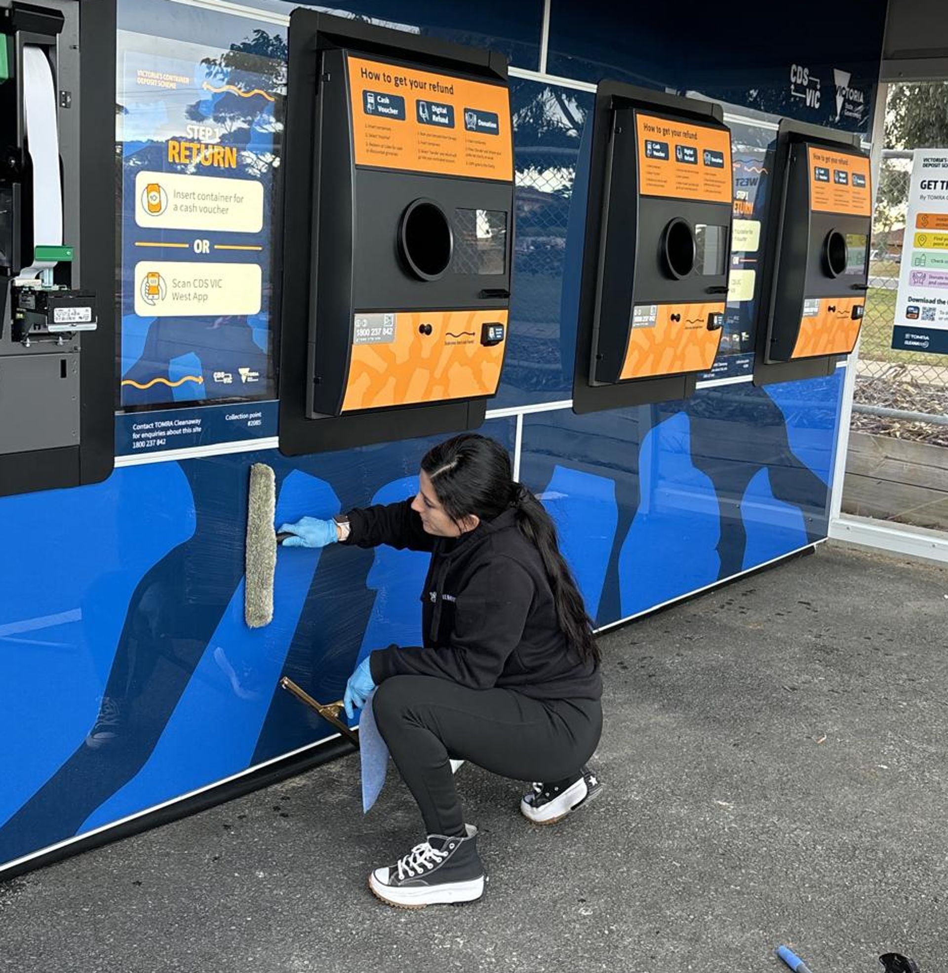 Clean Vibes employee cleaning the outside of a RVM machine