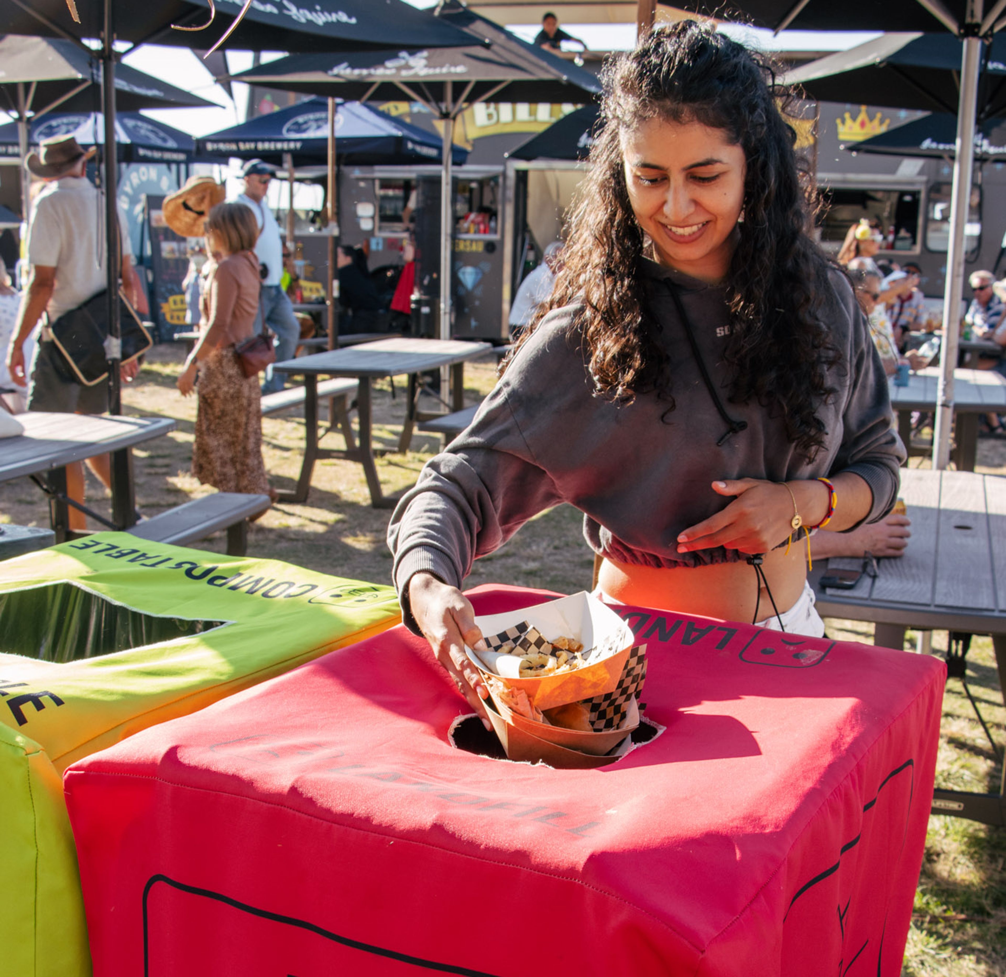 Event's patron throwing food container into a general waste bin