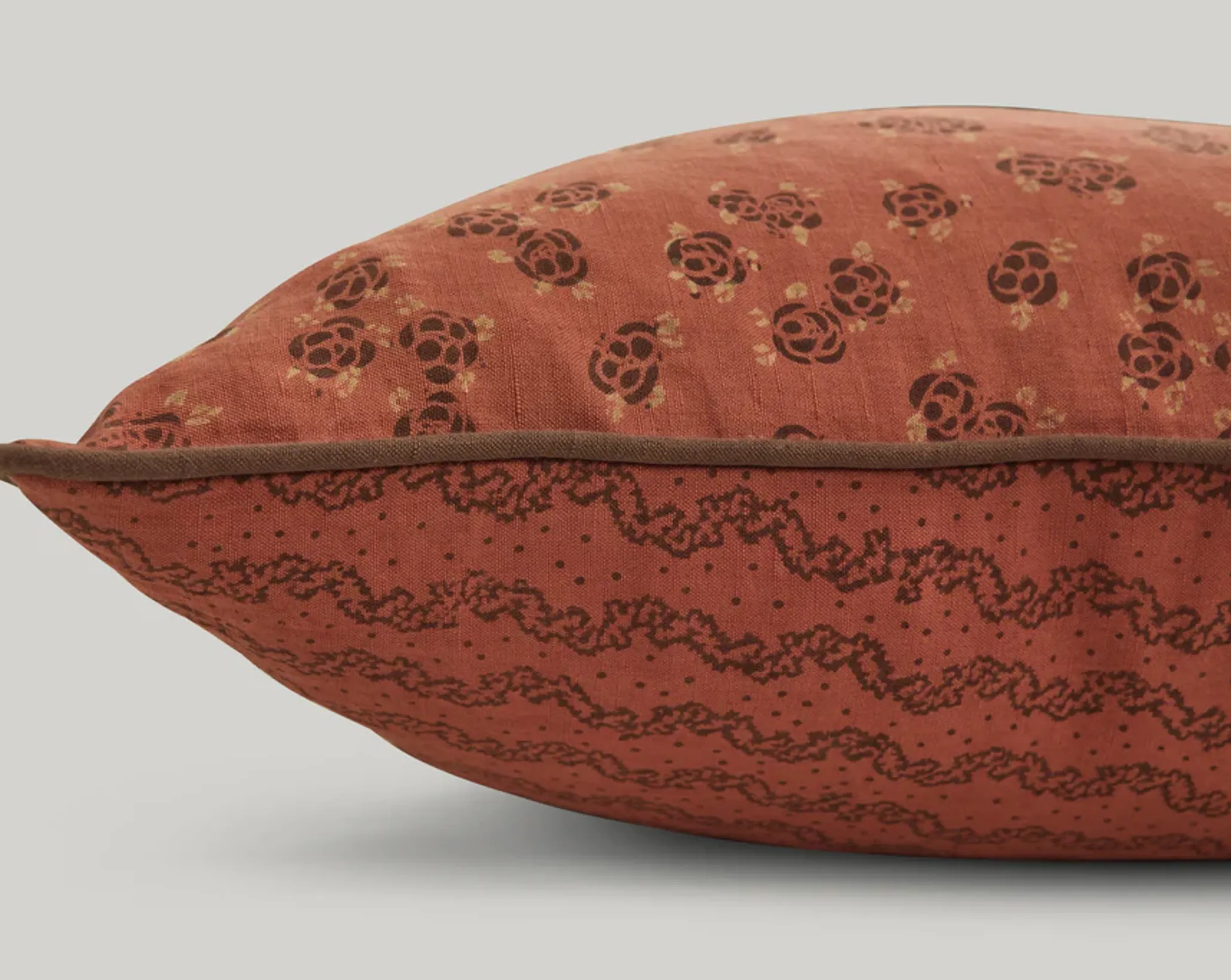 a close up of the studio ford marquise lumbar cushion in rust and cocoa colours