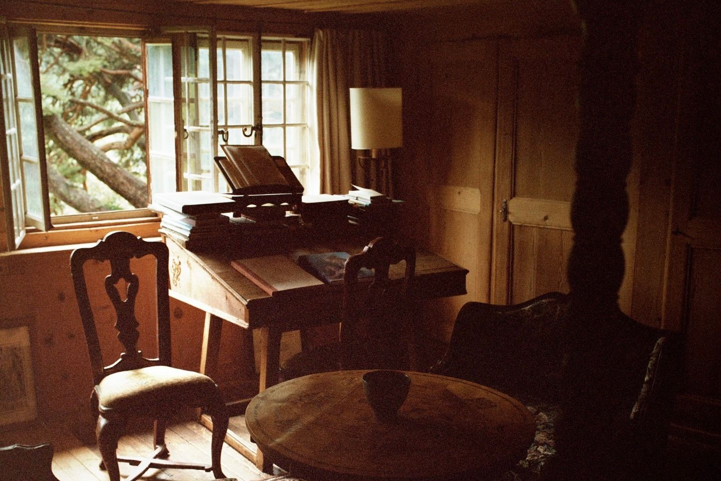 An interior shot from Scenery magazine no.4 with vintage wooden furniture and a window looking out to trees