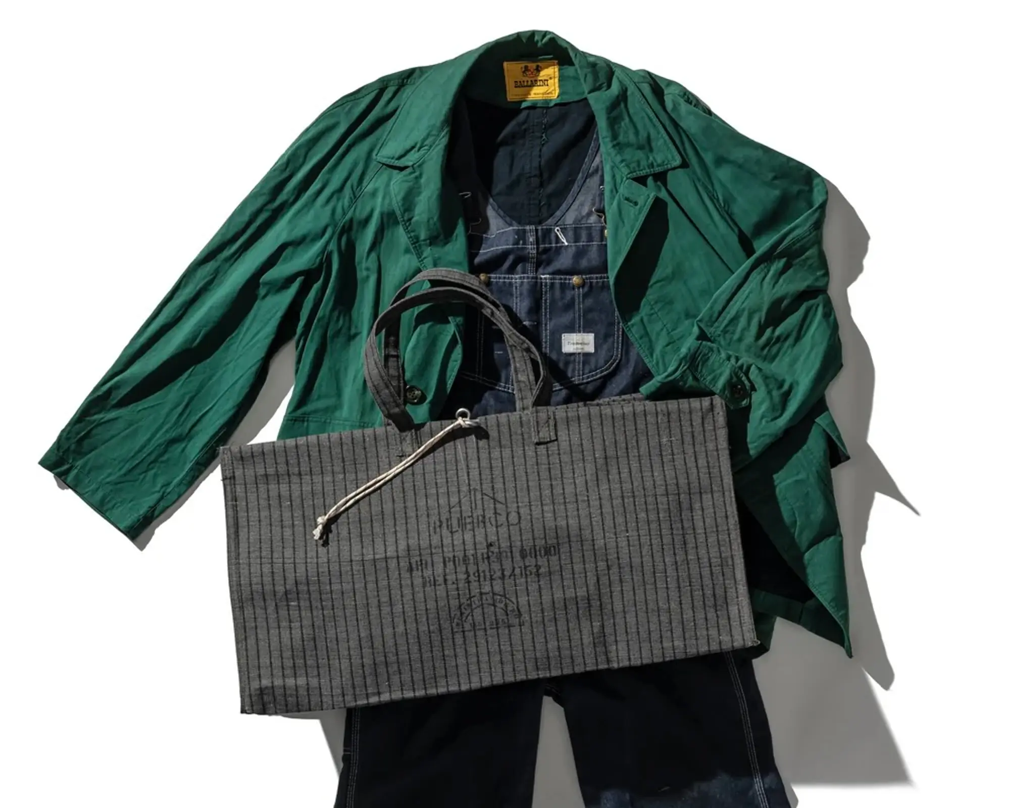 a flatlay of the Puebco waxed large canvas bag with an outfit underneath it
