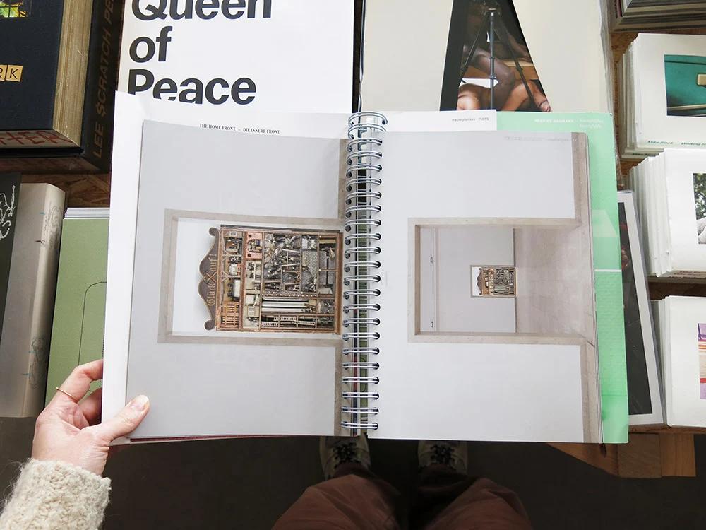 Henrike Naumann: Die Innere Front / The Home Front open to a spiral-bound exhibition spread featuring an installation from the German Pavilion at the Venice Biennale.