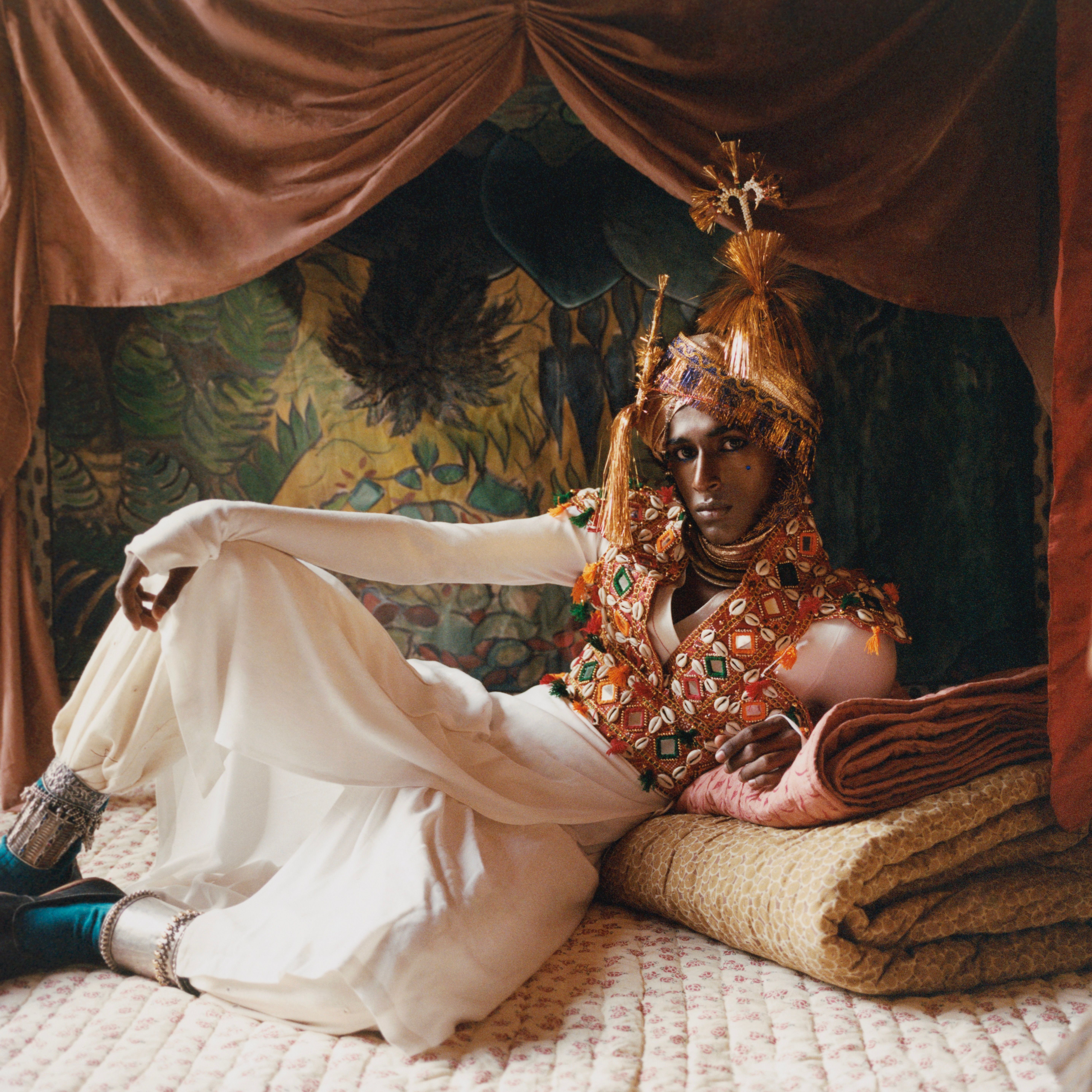 Model reclining on Studio Ford hand-stitched block-printed cotton quilts and bedding in an editorial campaign celebrating handmade textile craftsmanship, available at Handcrafted Modern.