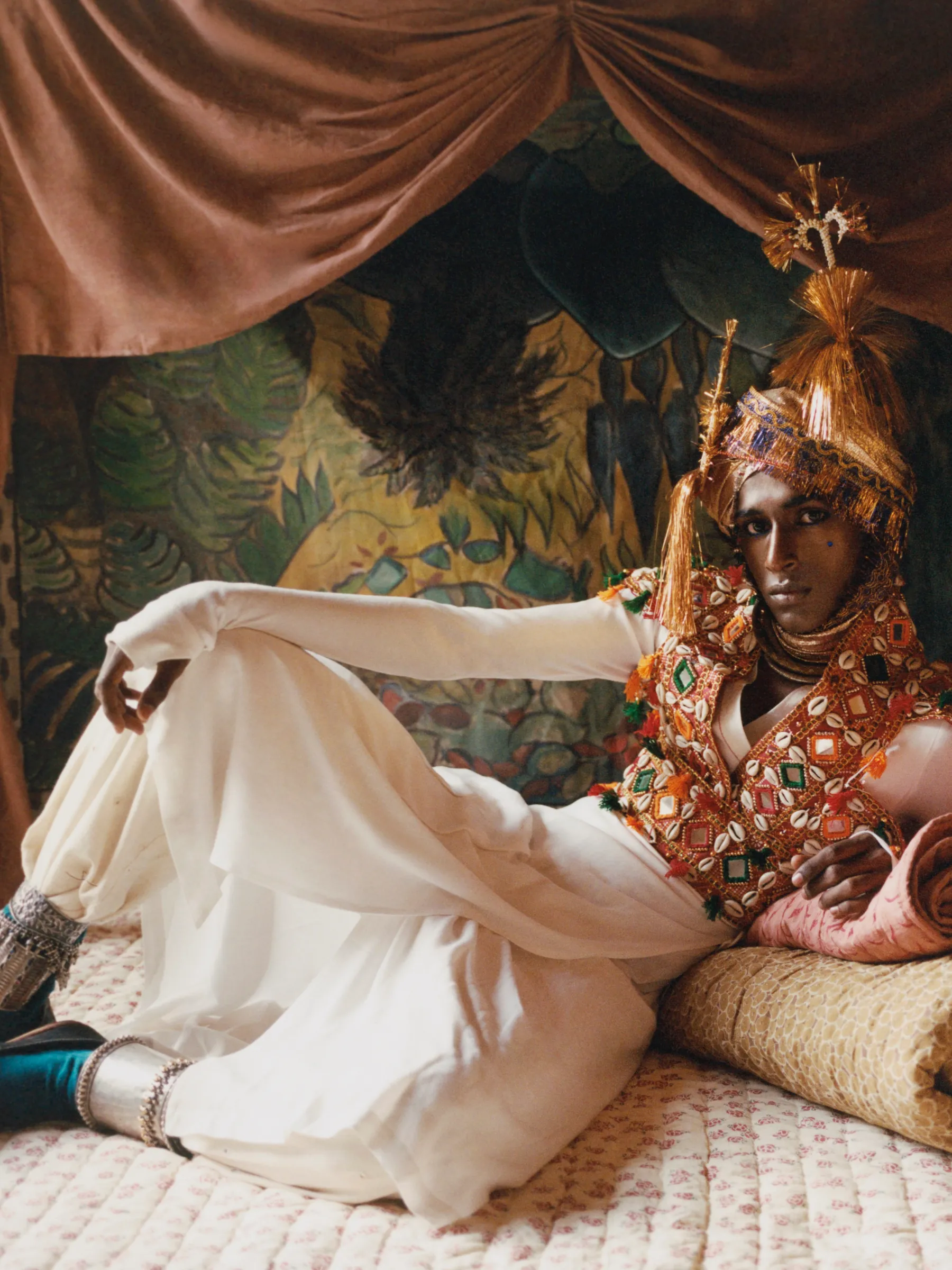 Model reclining on Studio Ford hand-stitched block-printed cotton quilts and bedding in an editorial campaign celebrating handmade textile craftsmanship, available at Handcrafted Modern.