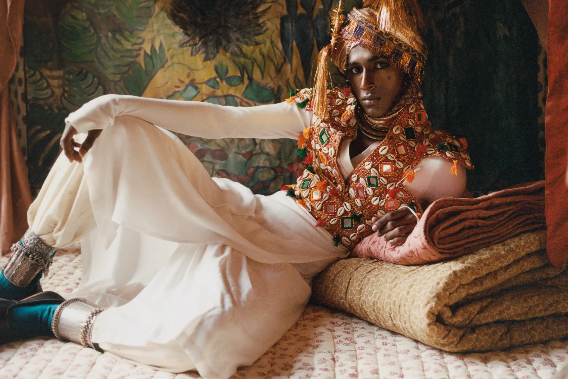 Model reclining on Studio Ford hand-stitched block-printed cotton quilts and bedding in an editorial campaign celebrating handmade textile craftsmanship, available at Handcrafted Modern.