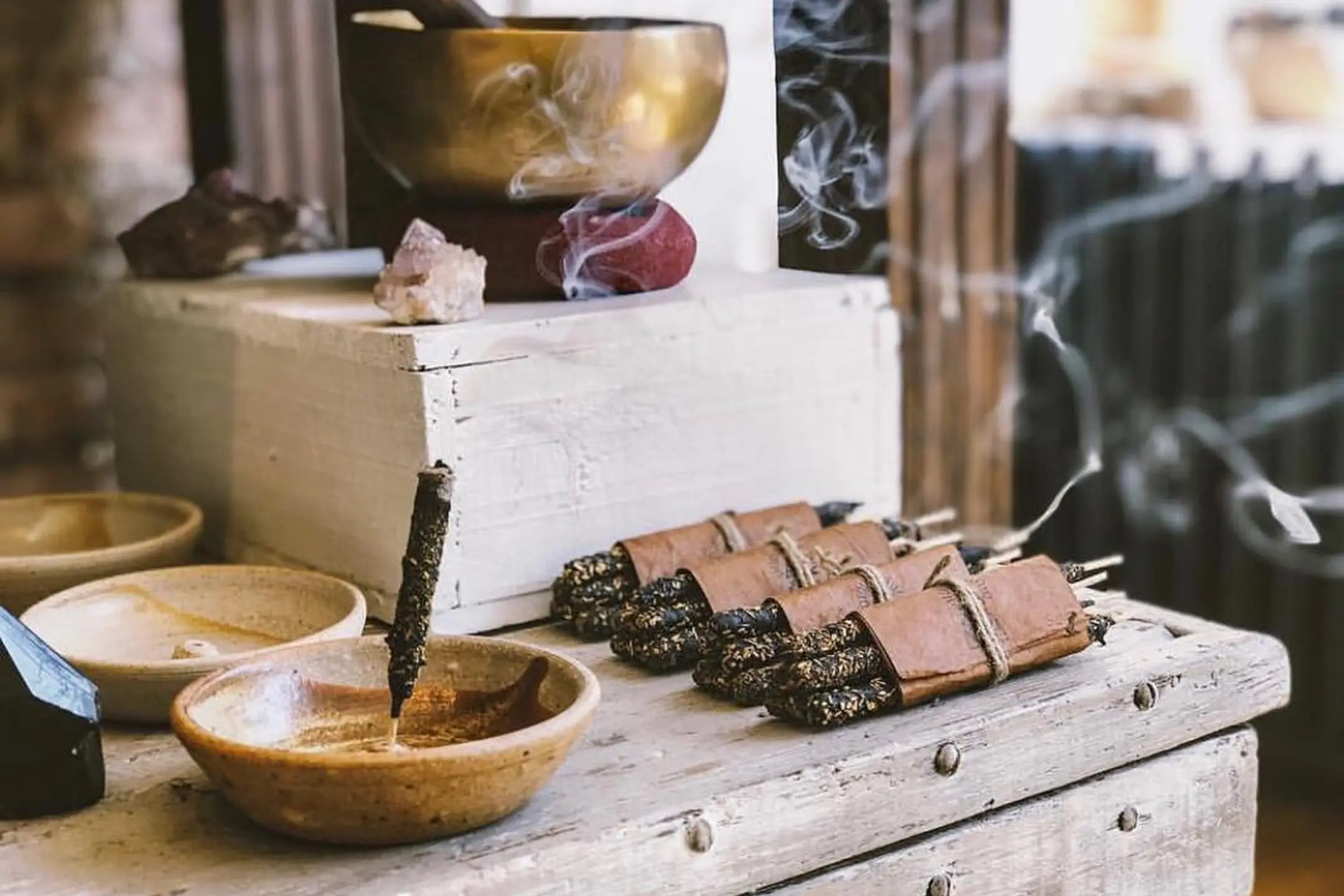 Incausa fair trade non-profit incense collection, singing bowls and pottery incense burners on a wooden table