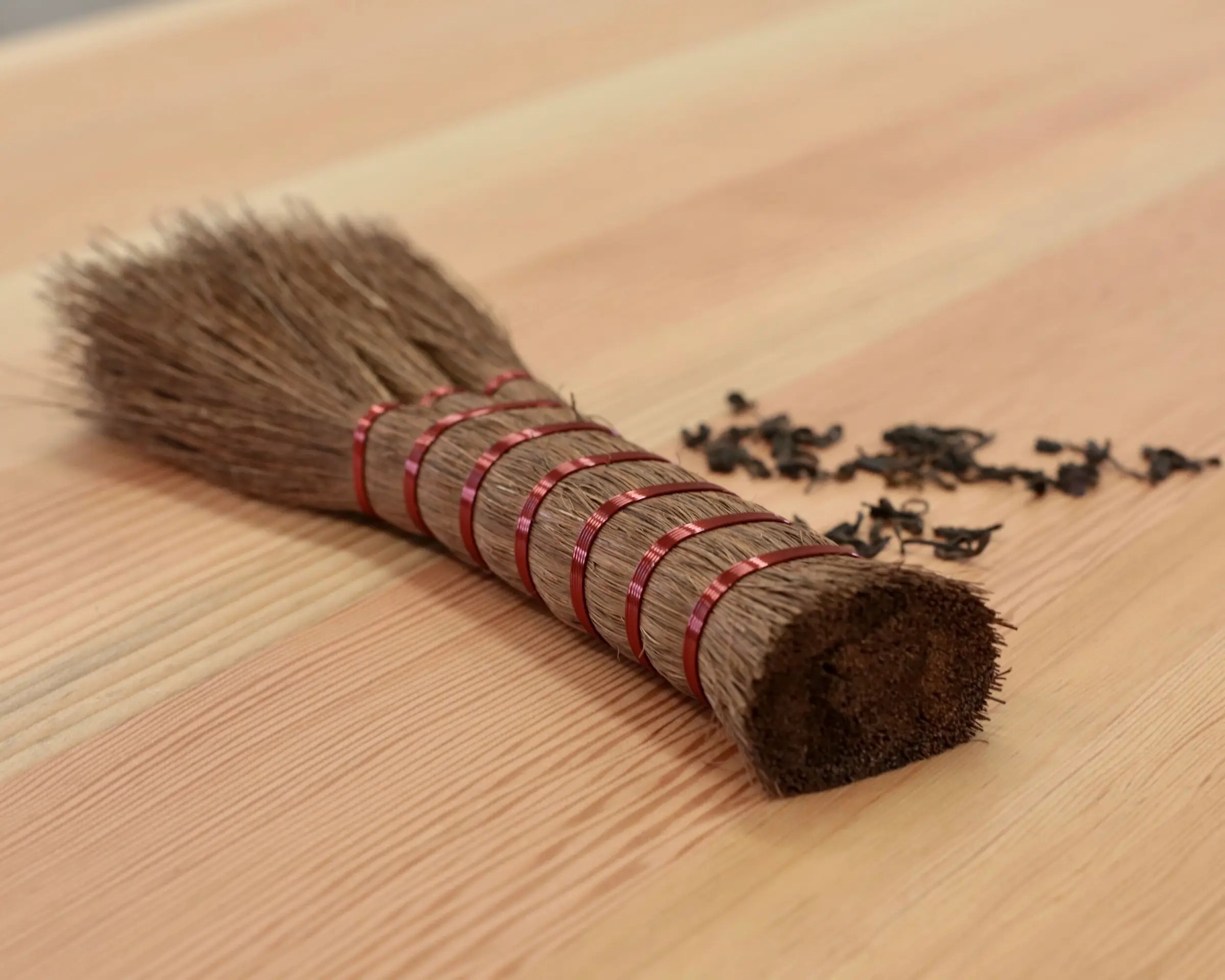 A niwaki share hand broom on a wooden table