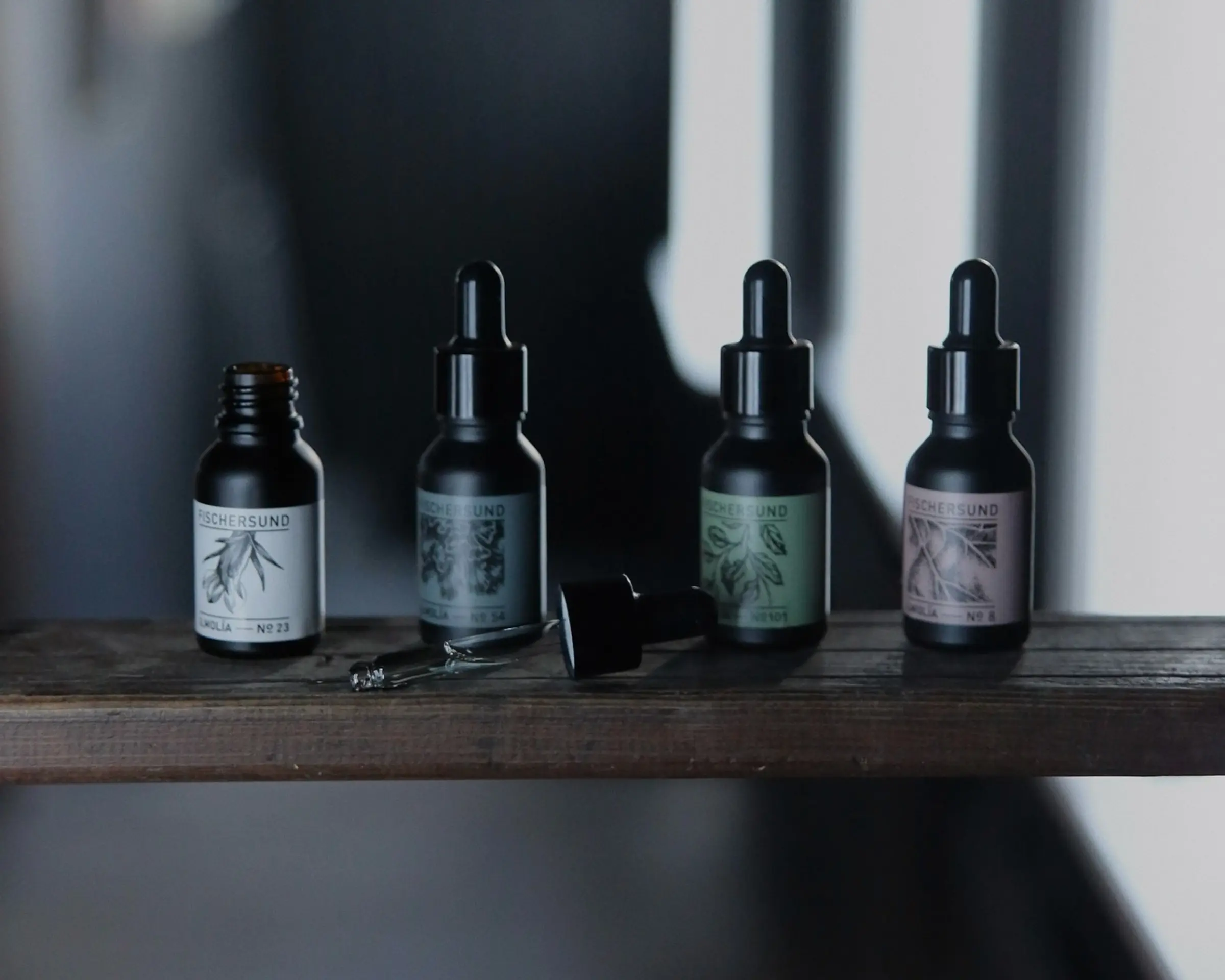 a collection of fischersund perfume oil on a wooden plank