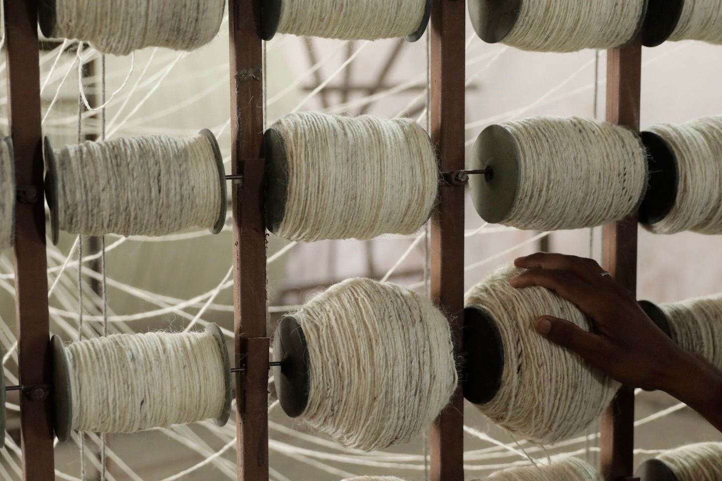 Spools of woollen yarn strung together with traditional weaving techniques