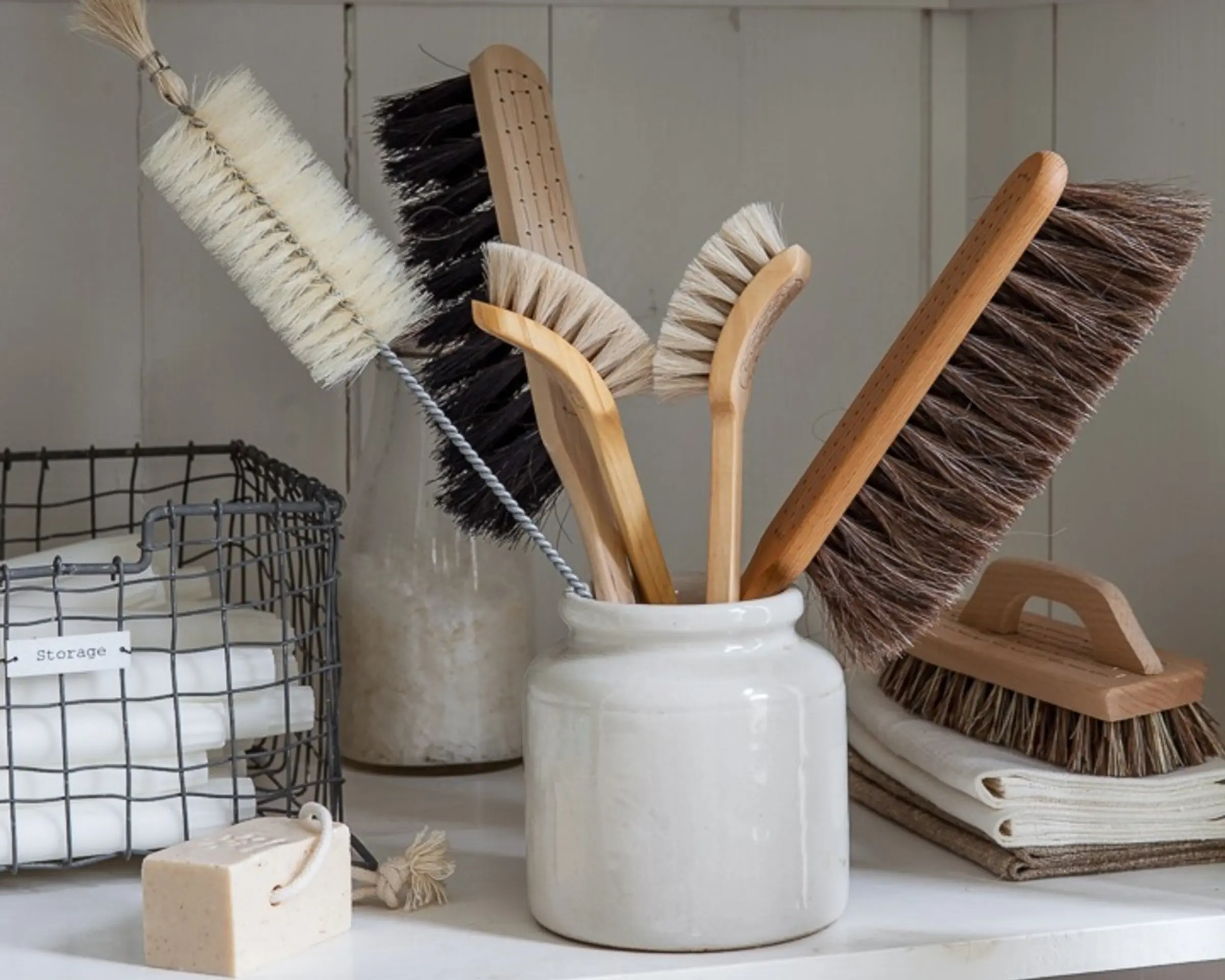a bundle of brushes in a pot on a shelf