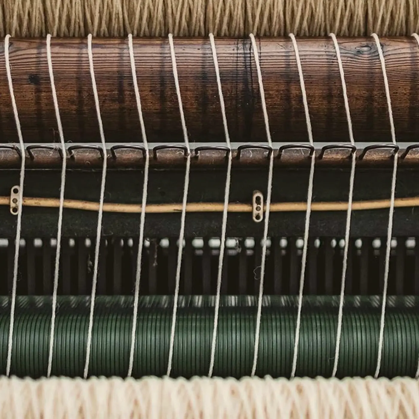 Close-up of a Burel merino wool blanket being woven on a historic loom in Portugal, showcasing traditional textile craftsmanship and hand-finishing, available at Handcrafted Modern.