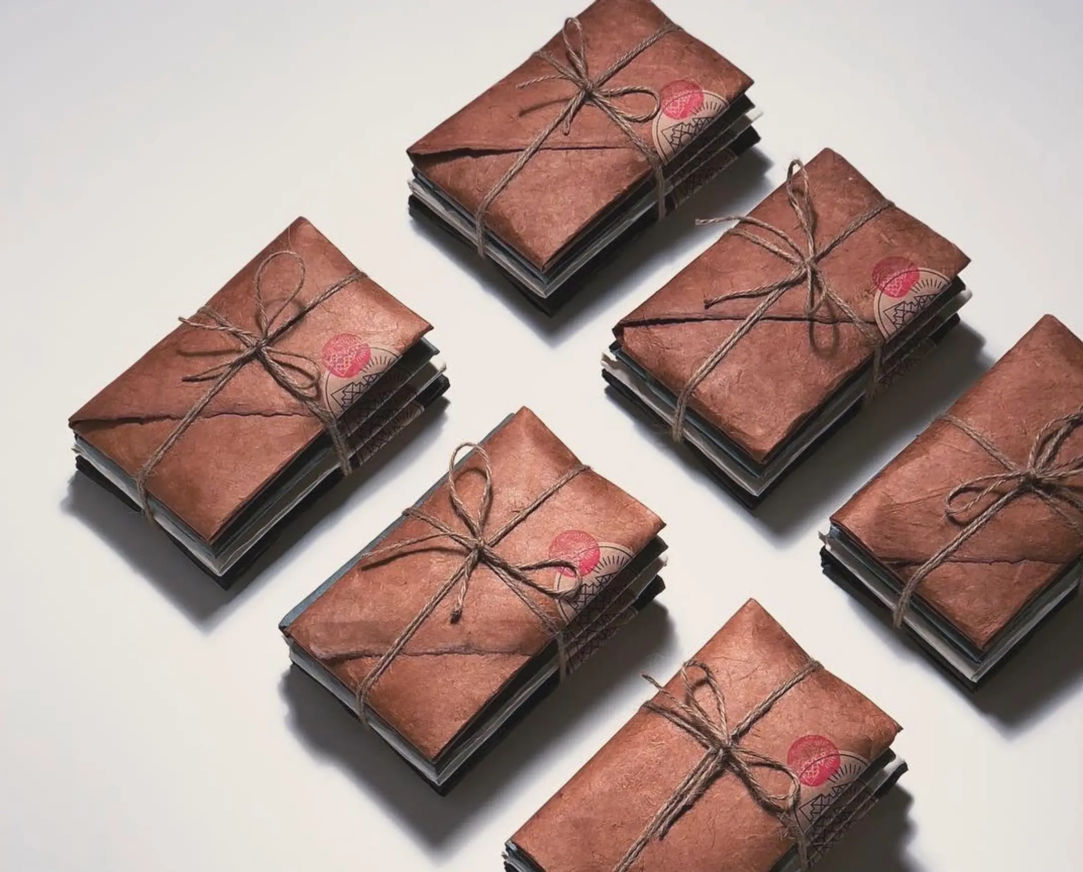 Four Incausa incense parcel assortments with decorative stamps on a beige surface