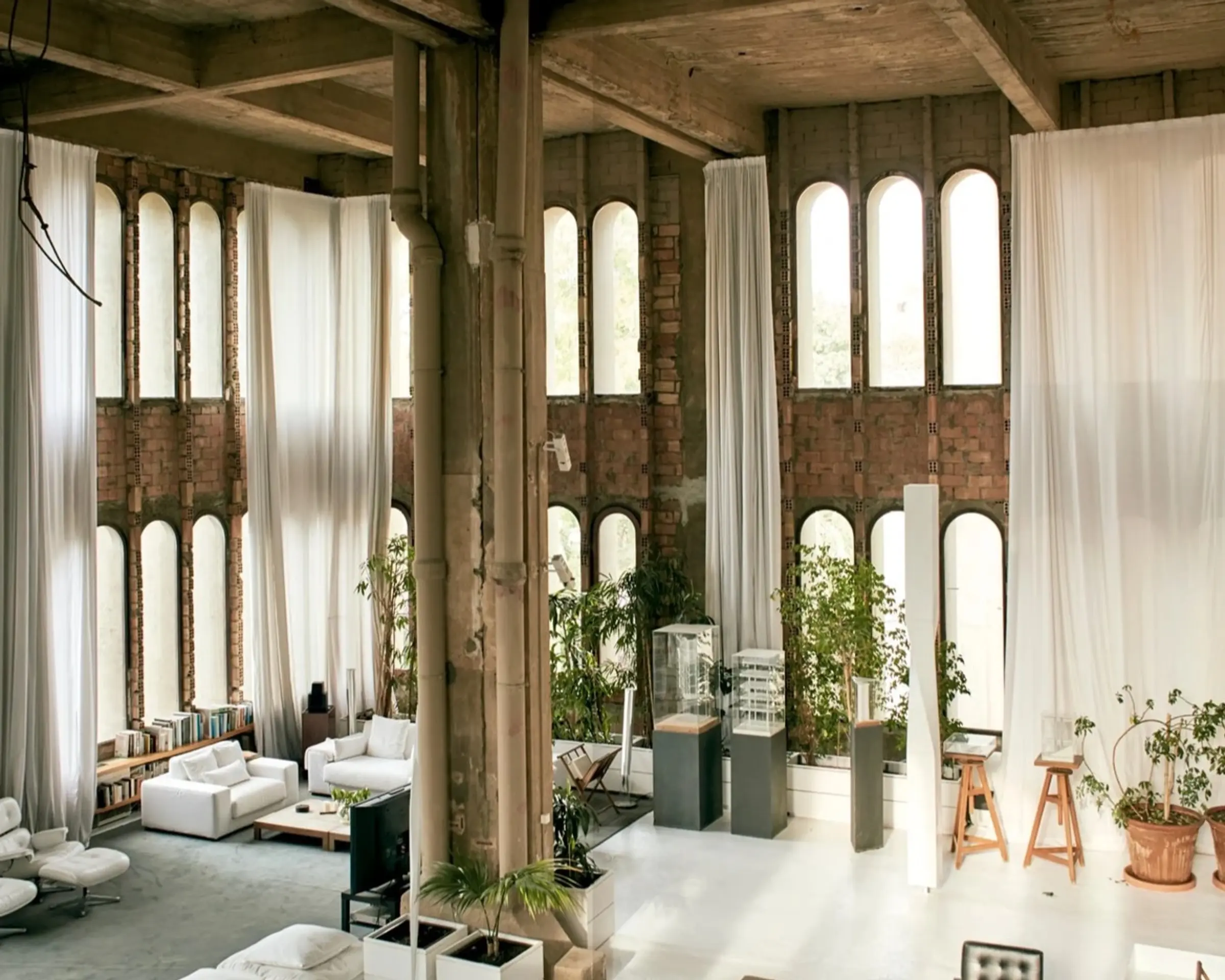 Photograph of a high ceiling room with concrete beams and skinny windows