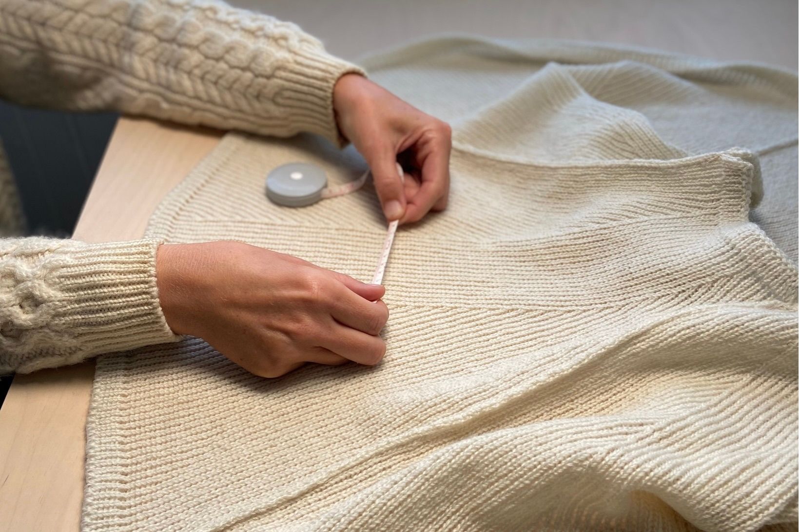 Sophie Poelman of Lof lights measuring one of her New Zealand made Wool light shades on a table.
