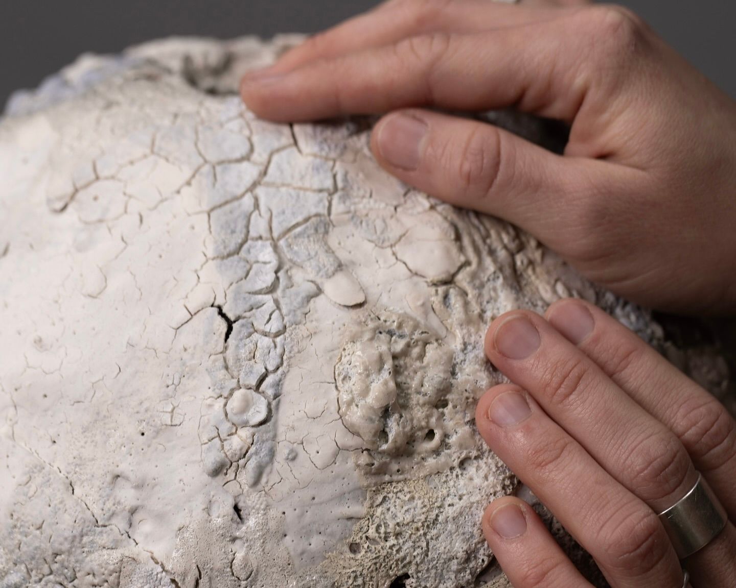 Maria of Loram ceramics holding a while lava glaze vase