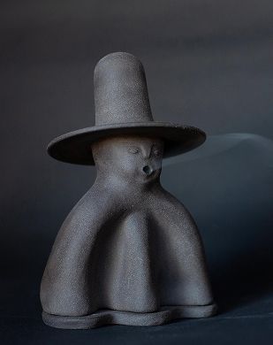A stoneware ceramic incense holder in the form of a man with a hat with incense smoke coming out of his mouth.