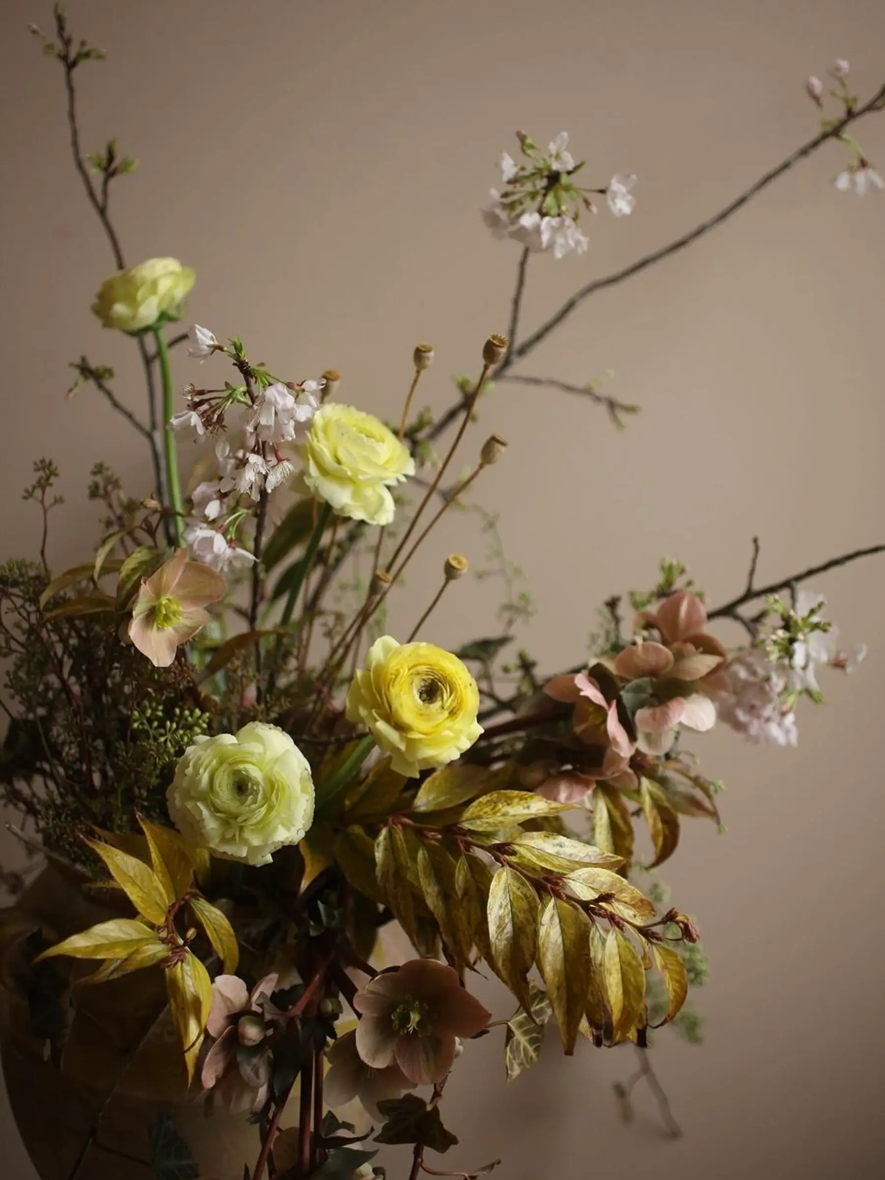 A floral arrangement photo in yellow tones on a brown wall