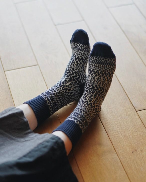 warm woolen socks worn on feet laying on a wood floor