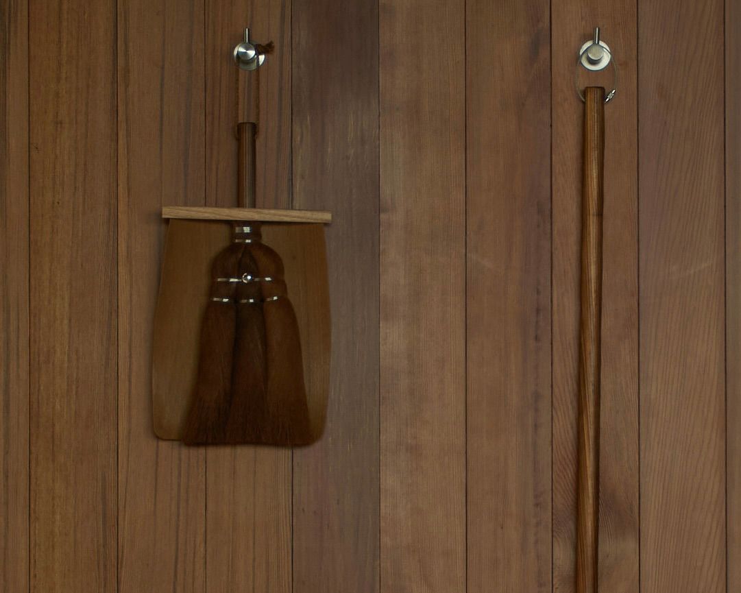 japanese cypress handbroom and wooden dustpan hanging on a wall