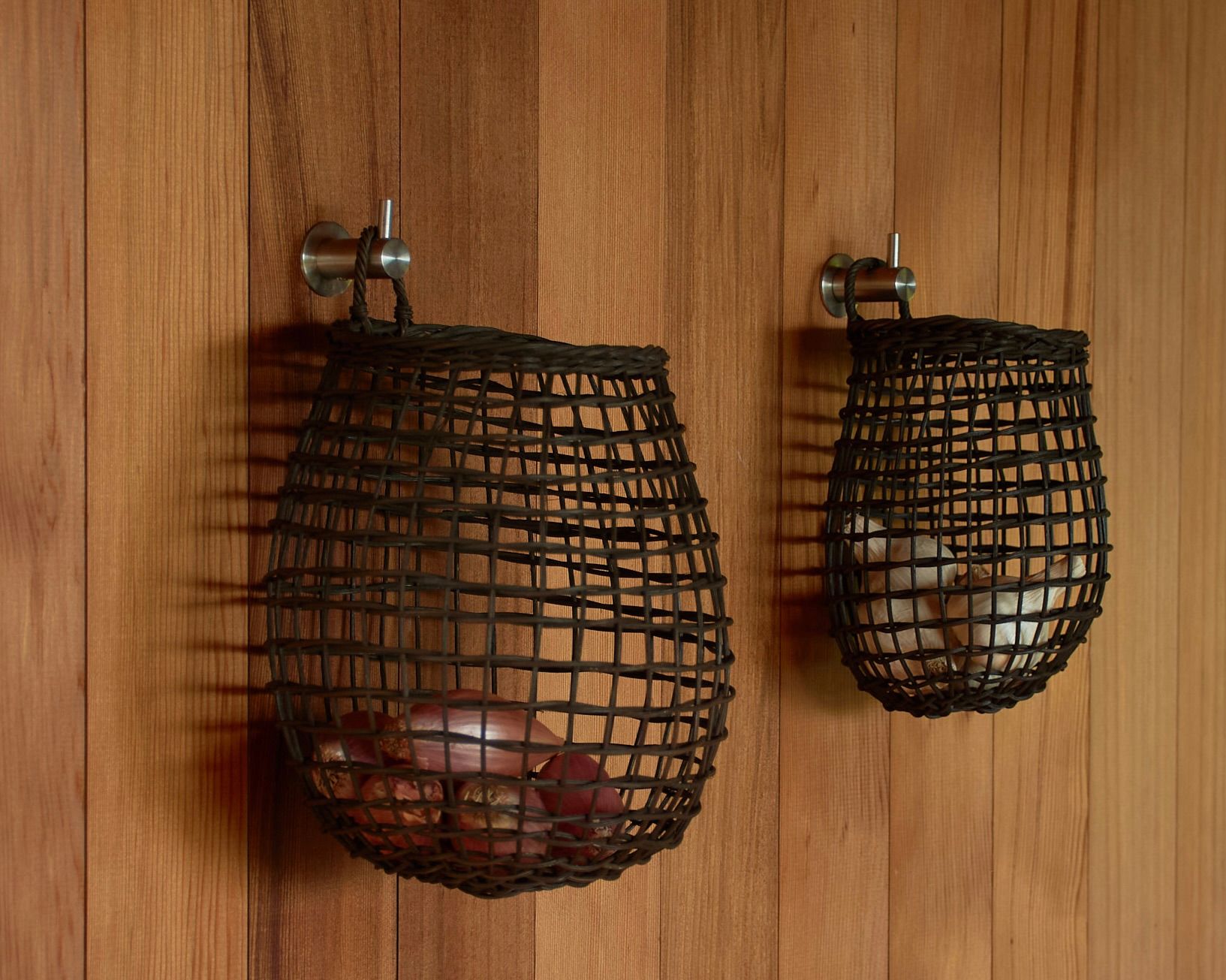 rattan core woven garlic baskets hanging on wood wall