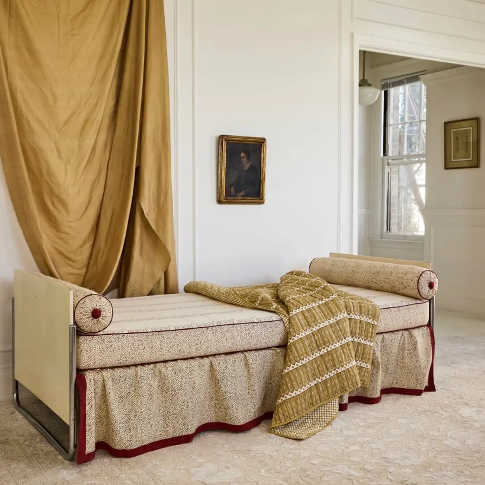 a room with draped curtain fabric and an antique couch with a studio ford aurea throw over it