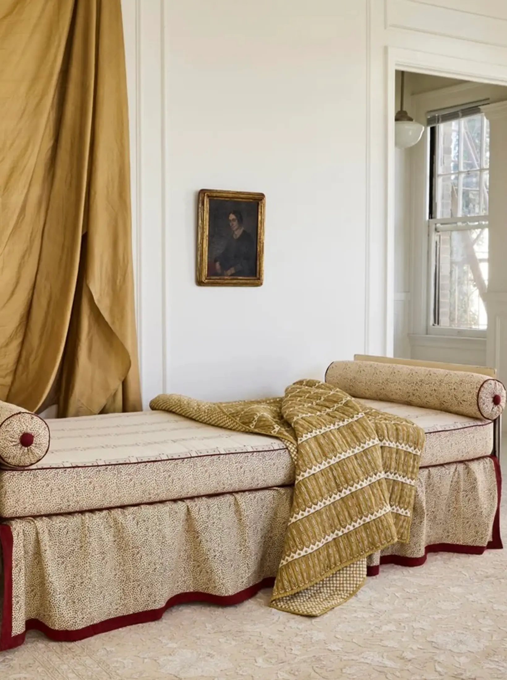 a room with draped curtain fabric and an antique couch with a studio ford aurea throw over it