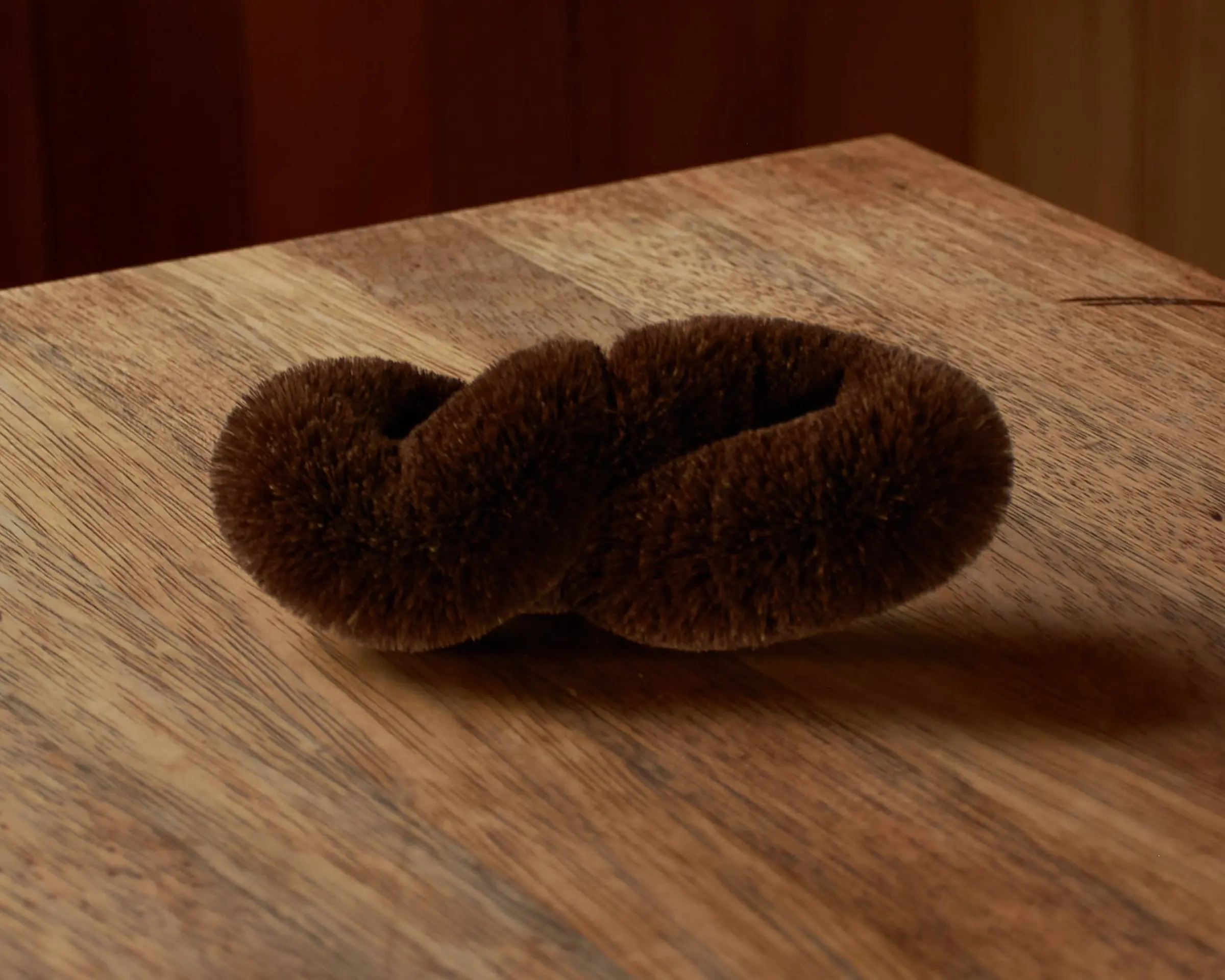 tawashi twist scrub brush on a wooden bench top