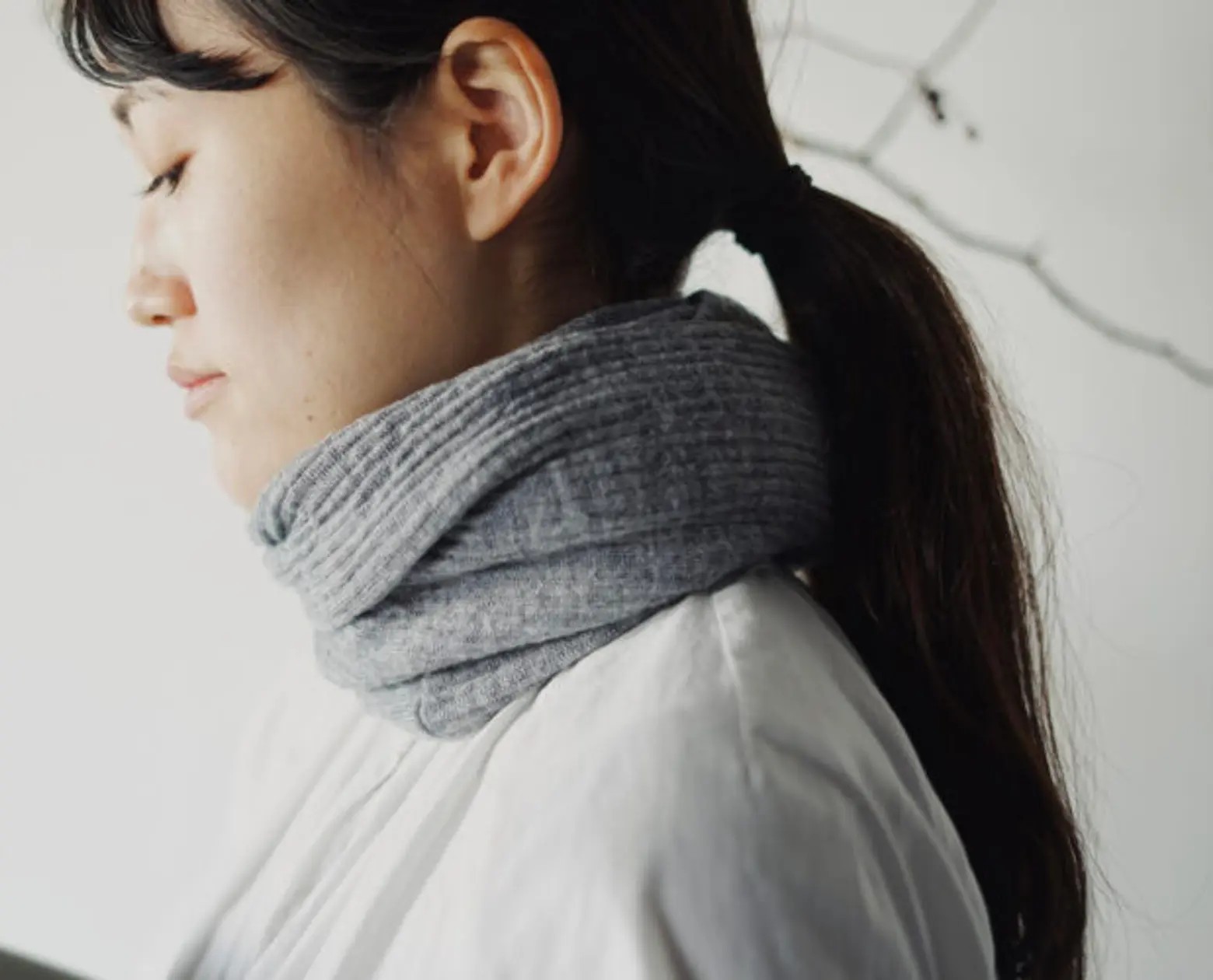 Super-soft snood made with fine, high-quality merino wool worn styled on a mode with a neutral background