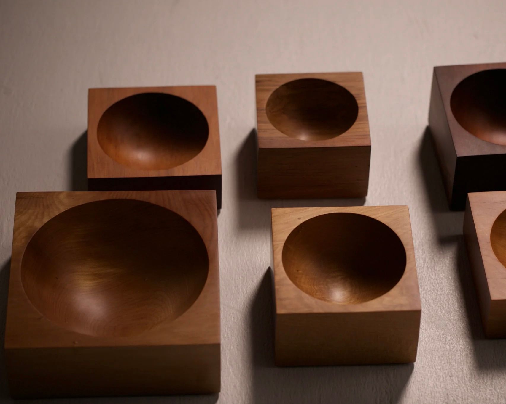 a group of Courtney Petleys Hemisphere bowls made from end grain native New Zealand timbers, hand carved in Aotearoa