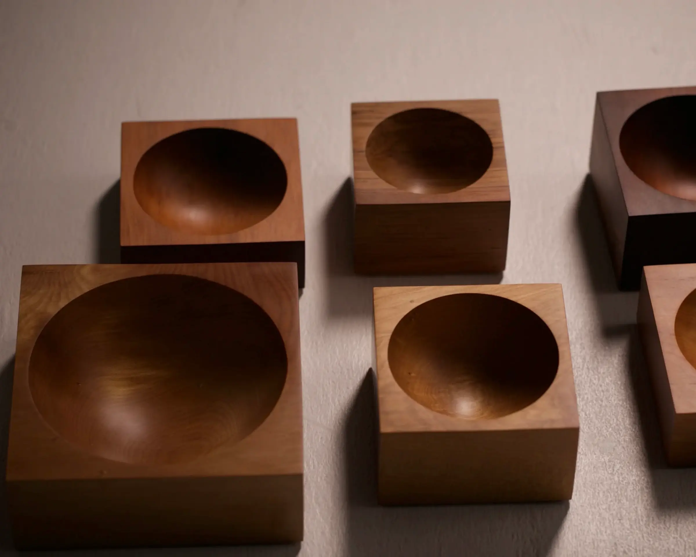 a group of Courtney Petleys Hemisphere bowls made from end grain native New Zealand timbers, hand carved in Aotearoa