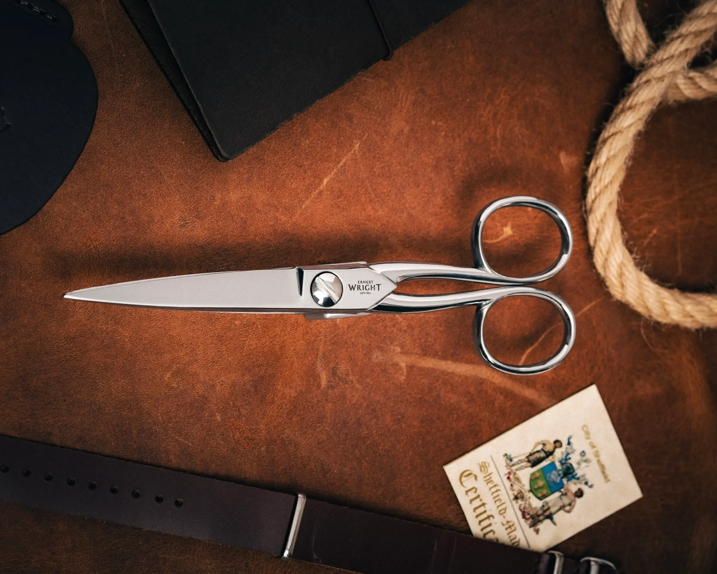 metal scissors with a leather case on a table