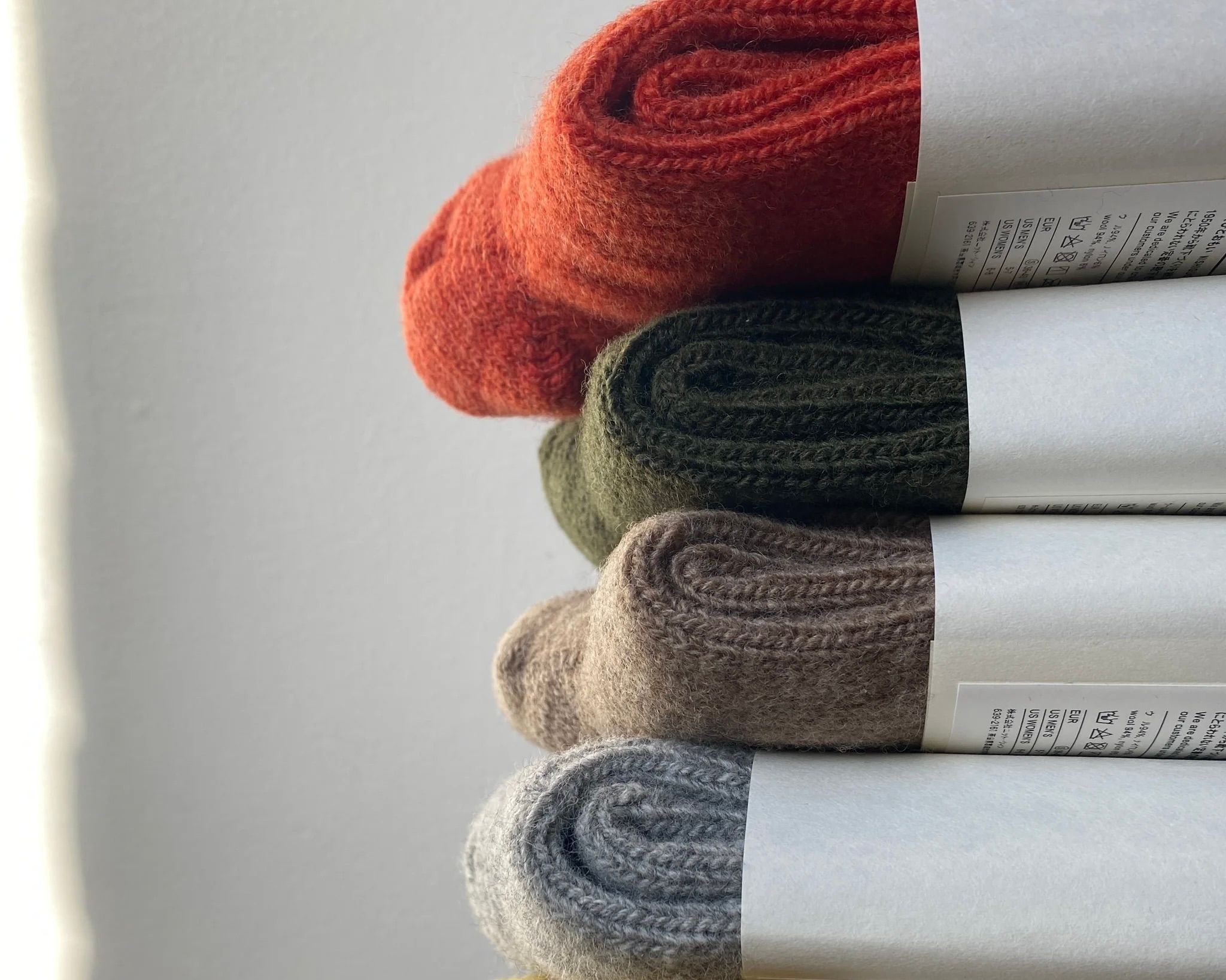 a stack of merino wool ribbed socks in natural colours from Nishiguchi Kutsushita
