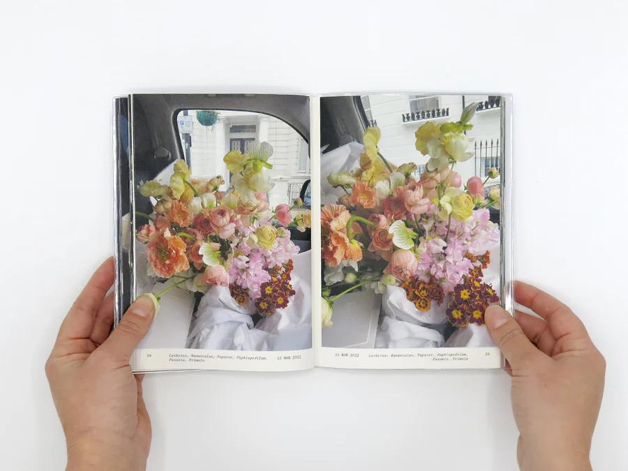 The book Flowers in the front seat by Simone Gooch opened showing images from inside of the book of a large bouquet of flowers sitting in her cars front seat