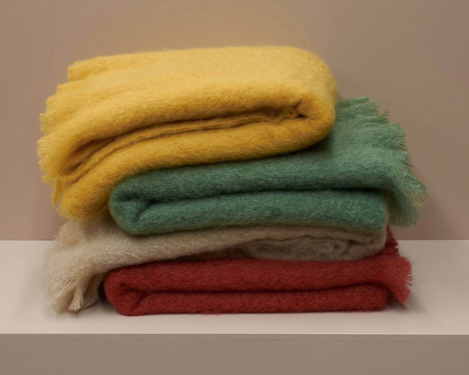 A stack of mohair blankets on a plinth