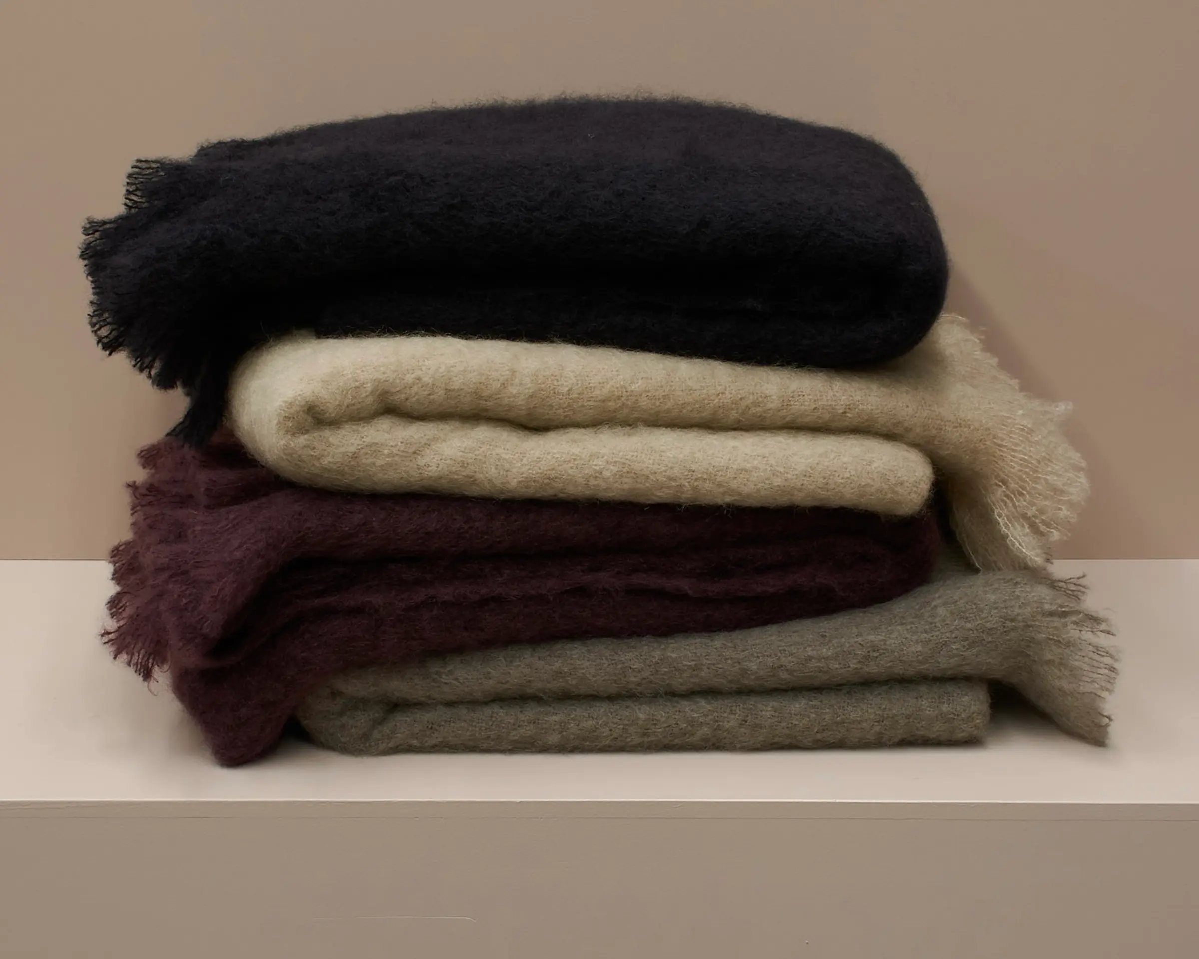 A stack of mohair blankets on a plinth