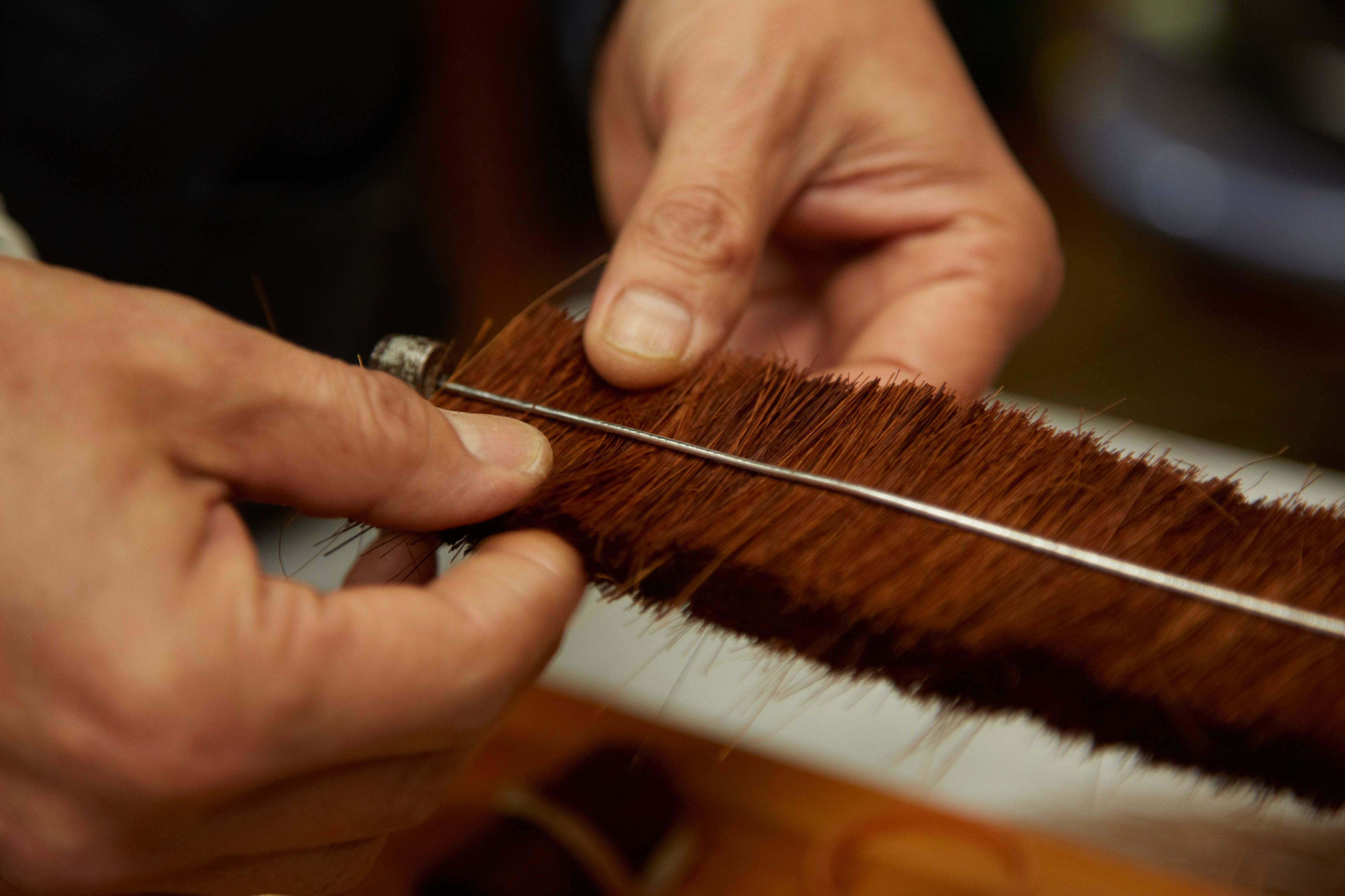 Palm fibre being twisted into a brush