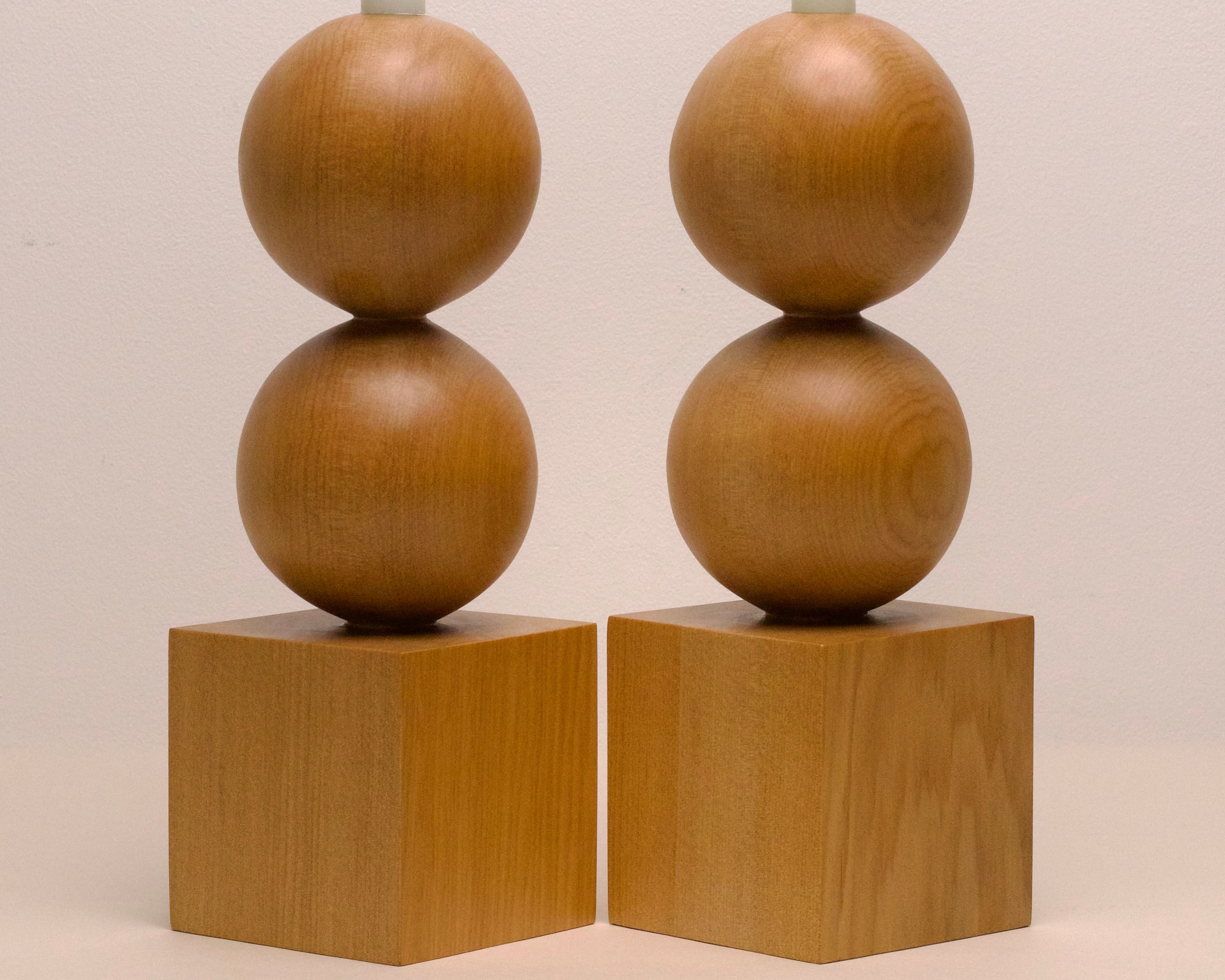 a pair of hand carved candle holders by New Zealand wood workers Courtney Petley with spherical and cube forms made from local kauri wood