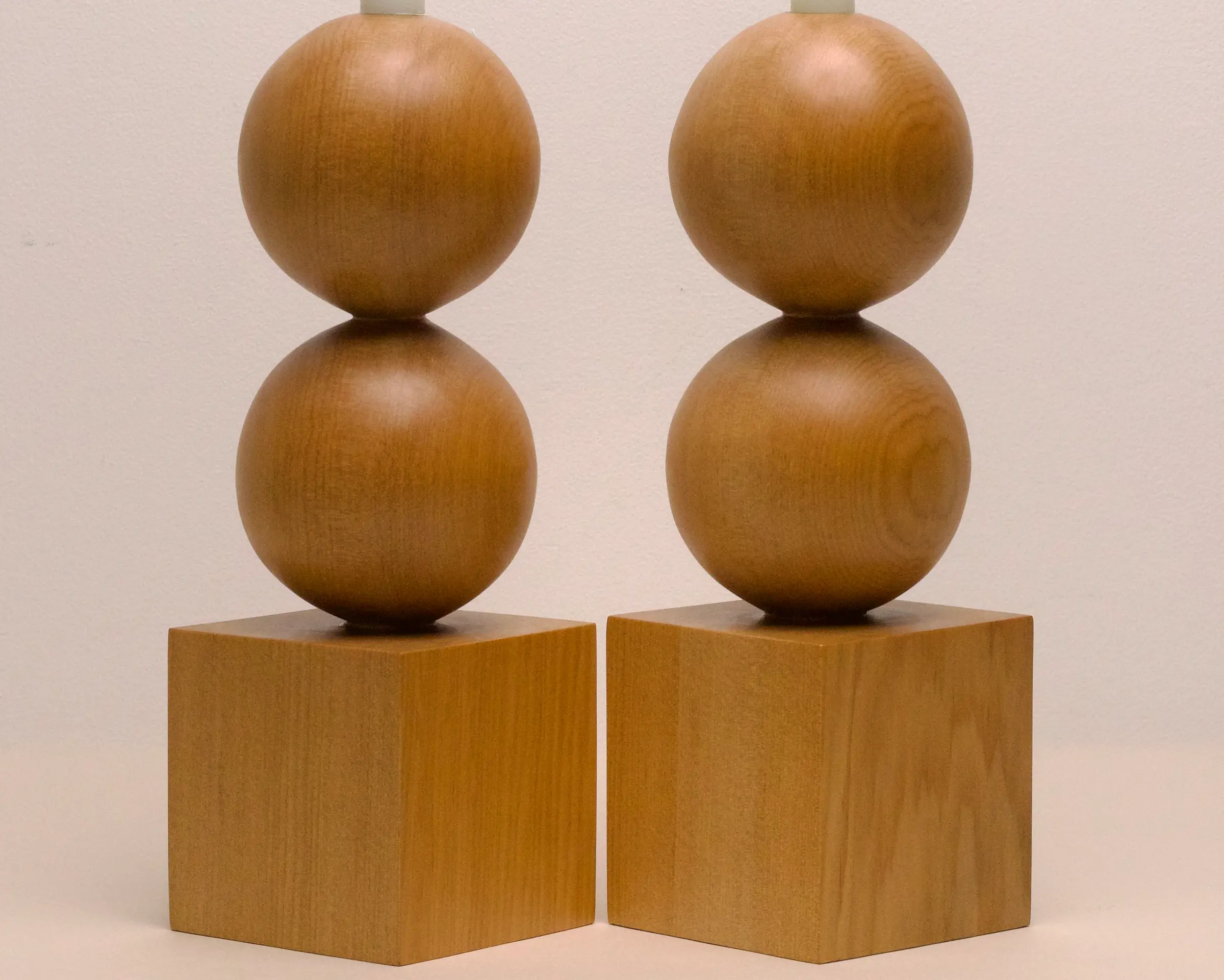 a pair of hand carved candle holders by New Zealand wood workers Courtney Petley with spherical and cube forms made from local kauri wood