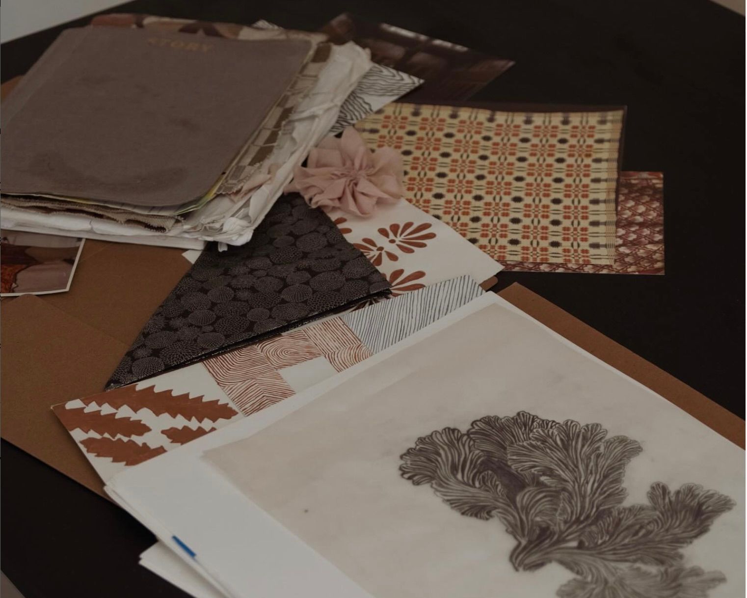 Inspiration drawings and swatches for textiles on a desk top.