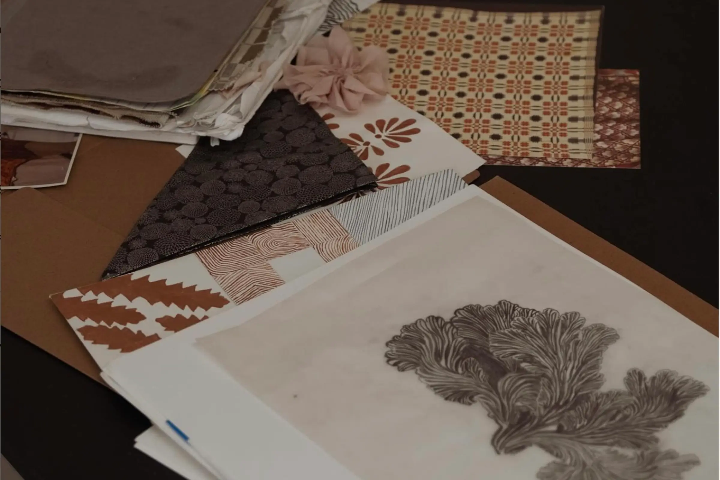 Inspiration drawings and swatches for textiles on a desk top.