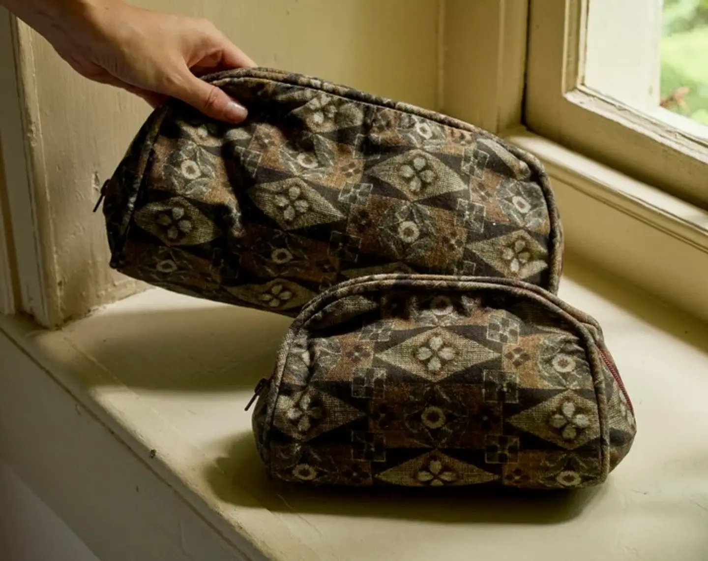 Autumn Sonata Emile wash bags on a window ledge surface