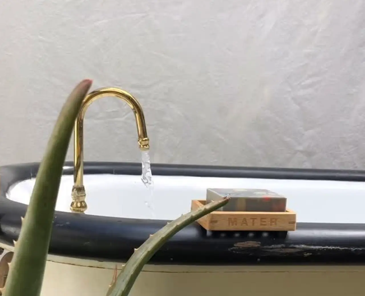 image of mater soap on the side of a bath with a gold tap