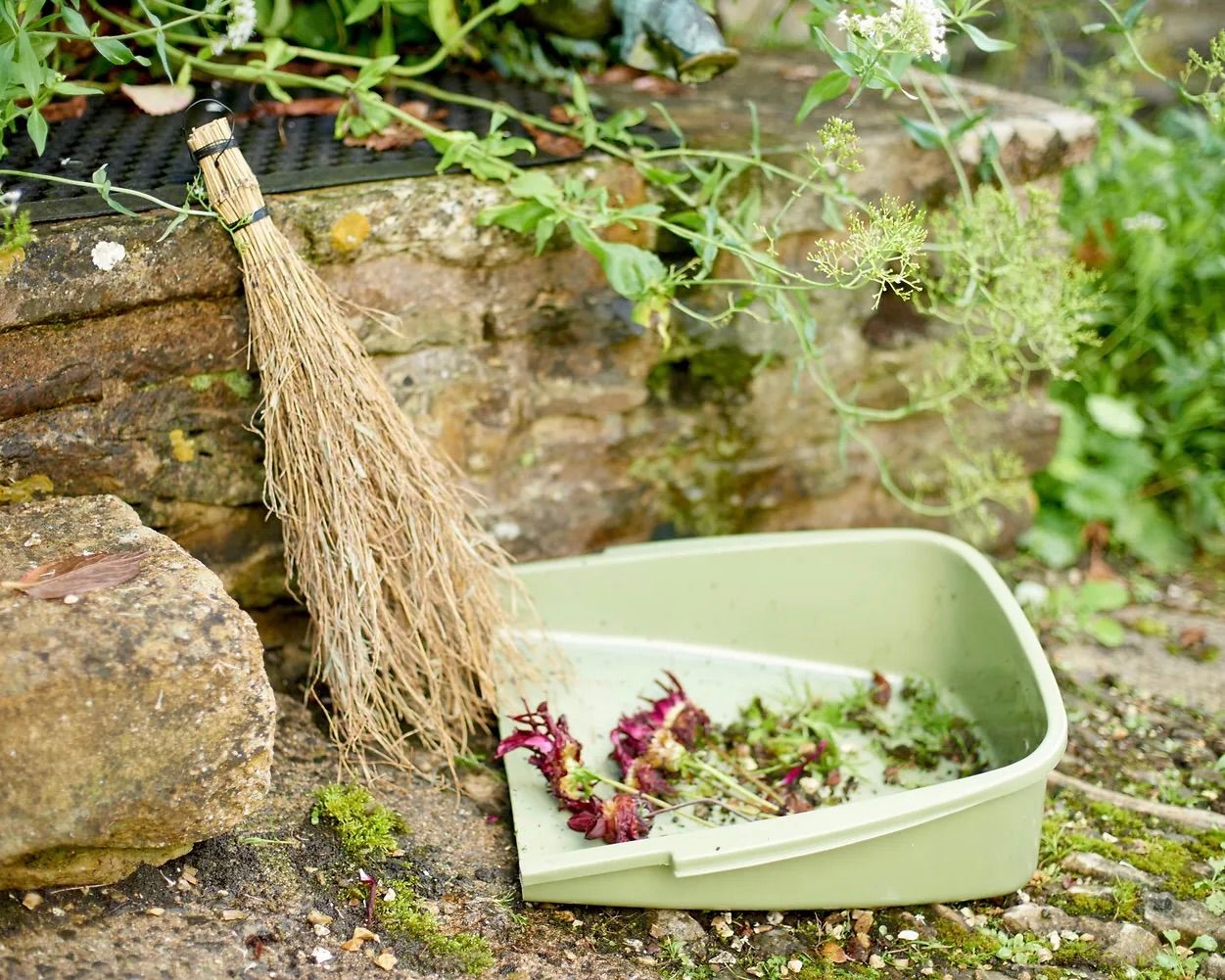 bamboo handbroom and an enormous leaf pan in a garden setting