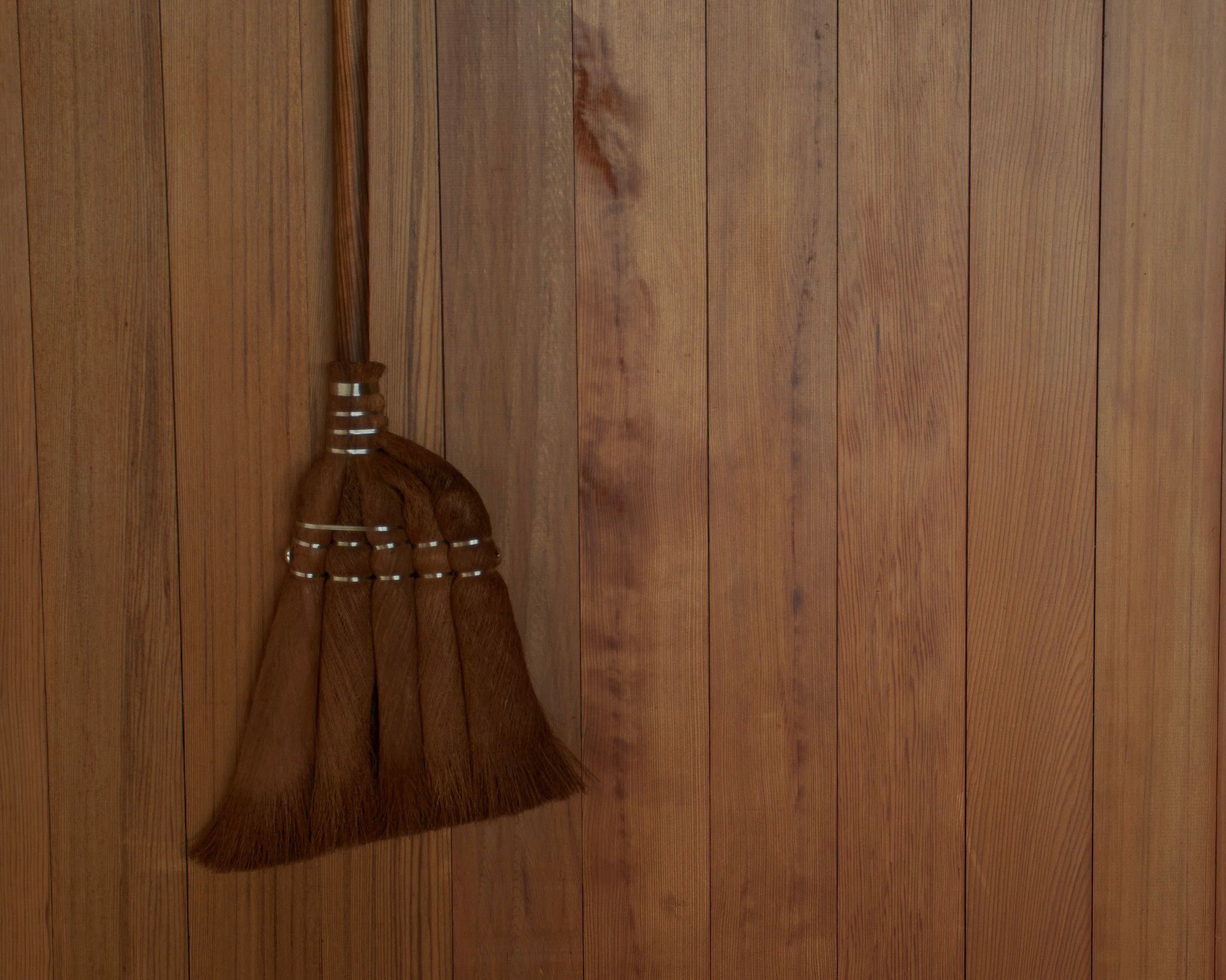 Brushes, brooms, body brushes hung up on a white wall