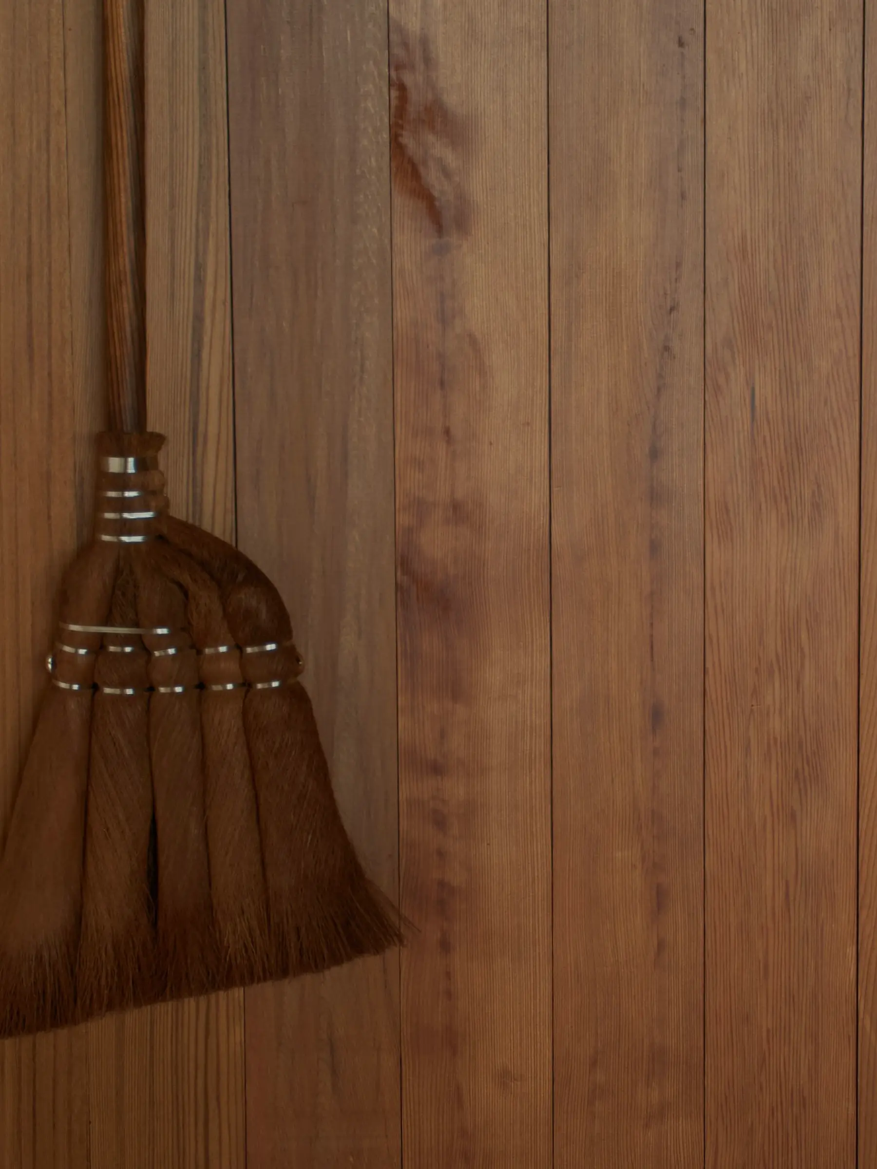 Brushes, brooms, body brushes hung up on a white wall